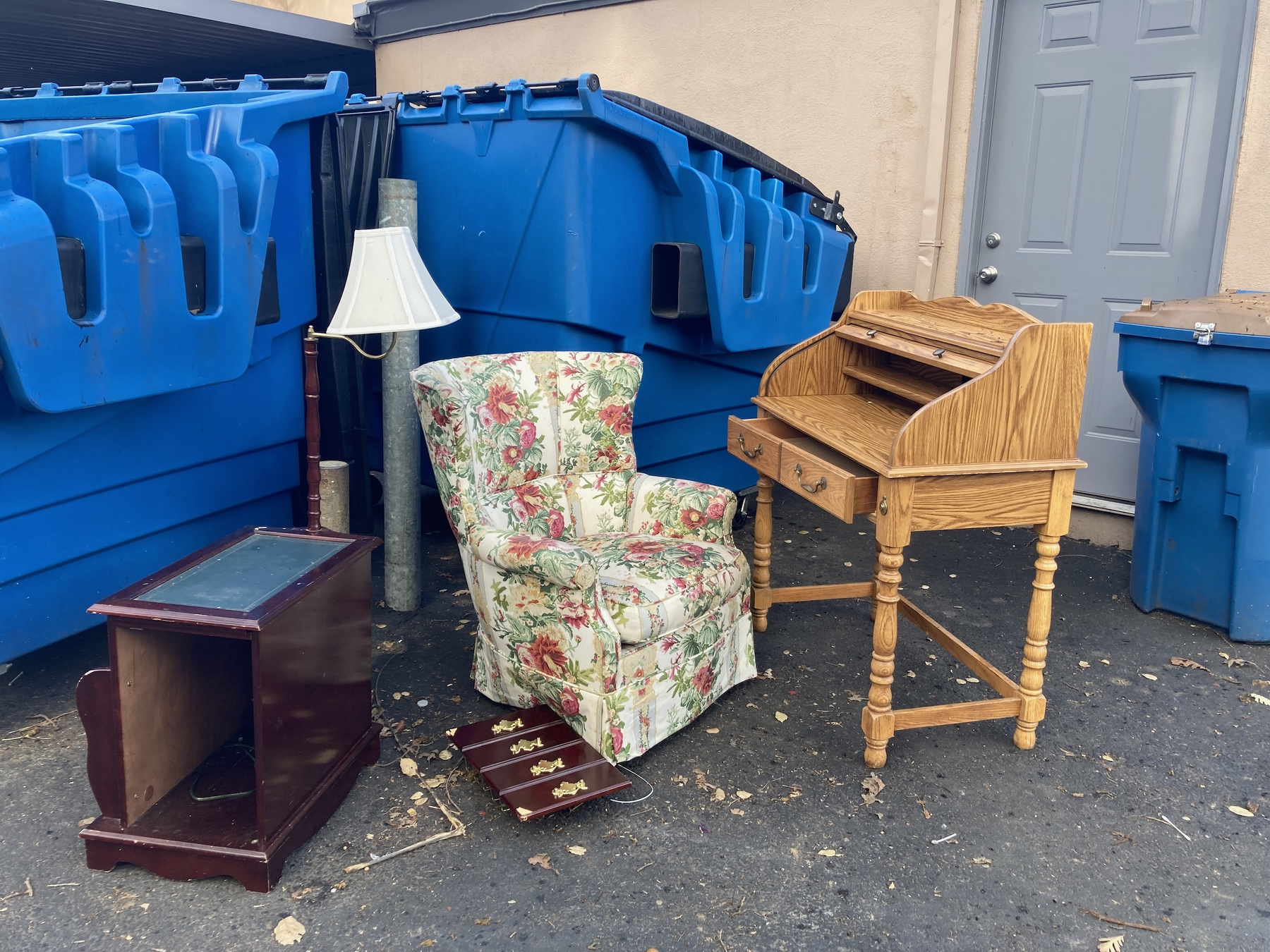 Furniture sitting next to a large garbage bin