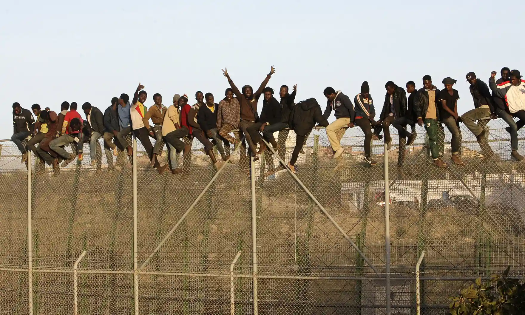 People sit on top of a fence as they attempt to reach Melilla from Morocco in 2014. Photograph: Francisco G Guerrero/EPA