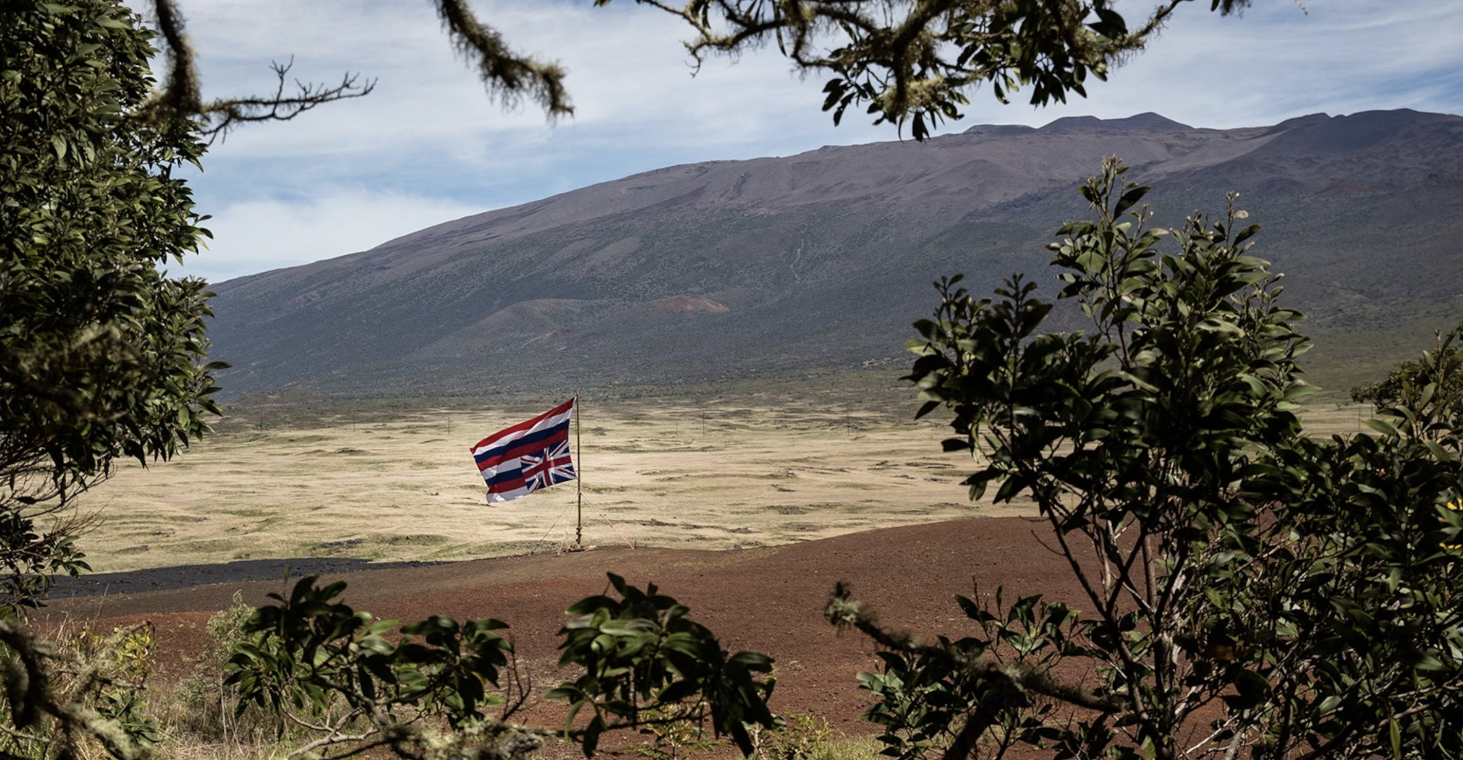 An inverted Hawaiian state flag, a symbol of the islands’ sovereignty movement, flies at Mauna Kea, a volcano on the island of Hawaii. Photo by Daniella Zalcman