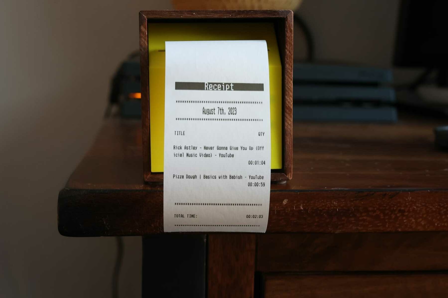 A machine showing a receipt that lists youtube videos watched and their duration. 