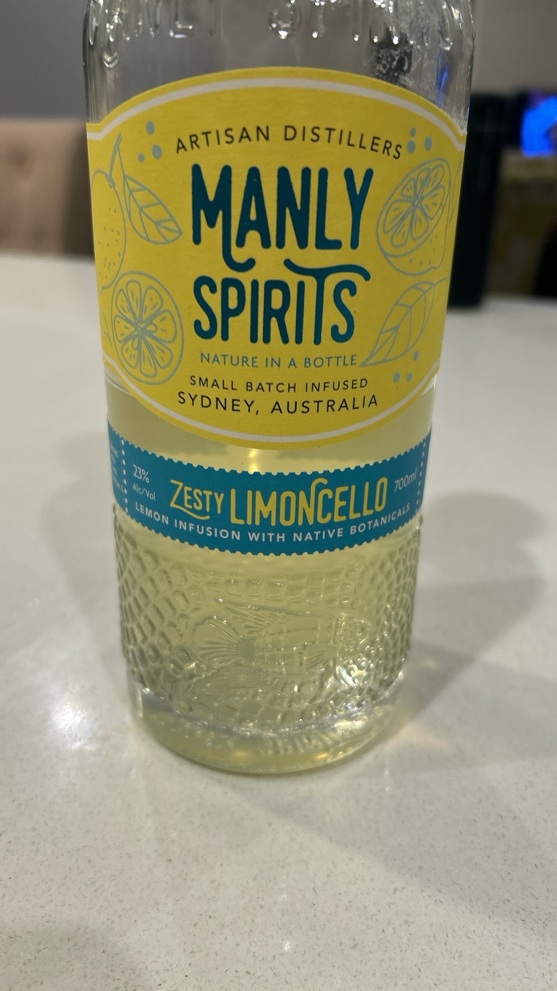 A bottle of yellow liquid that bears the label "zesty limoncello". Zesty is now slang for flamboyantly, or dashingly, gay. 