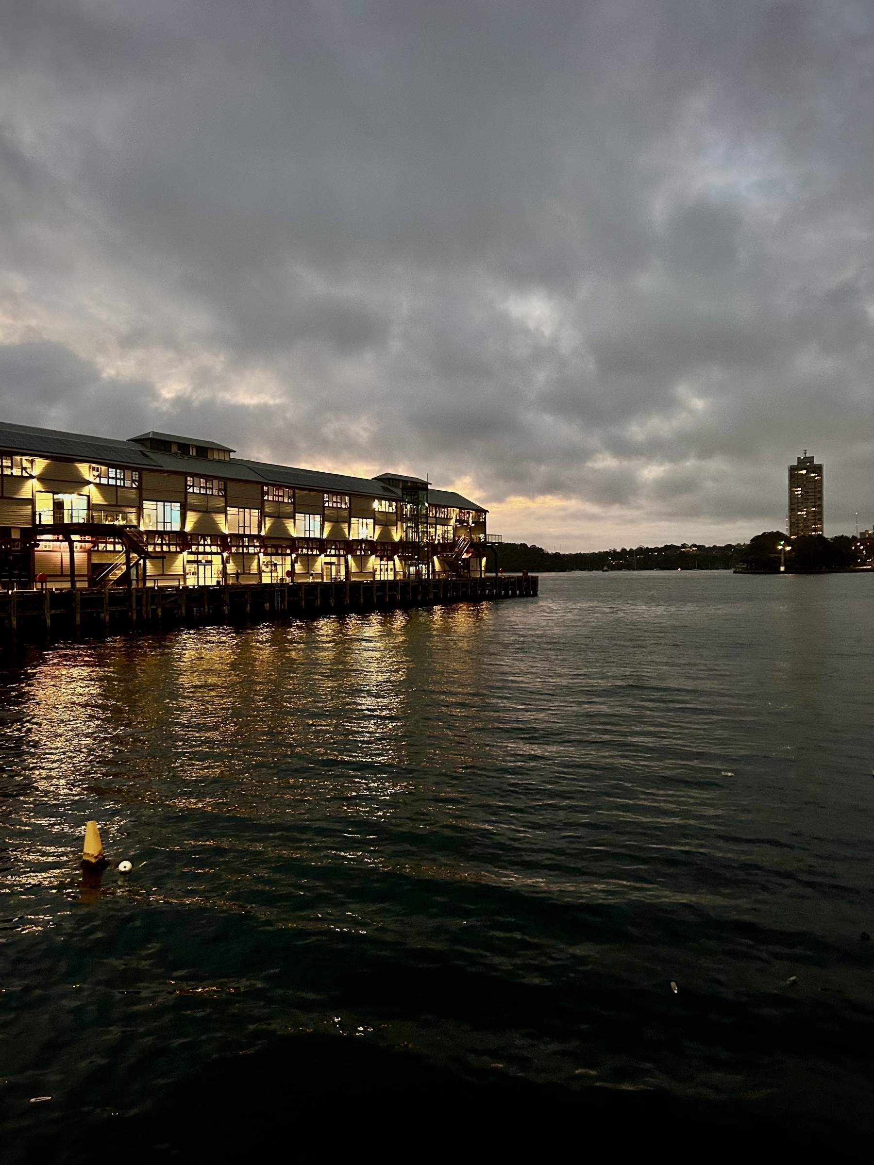 Walsh Bag wharf at dusk on Sydney Harbour. Blues Point Tower is visible in the distance. 