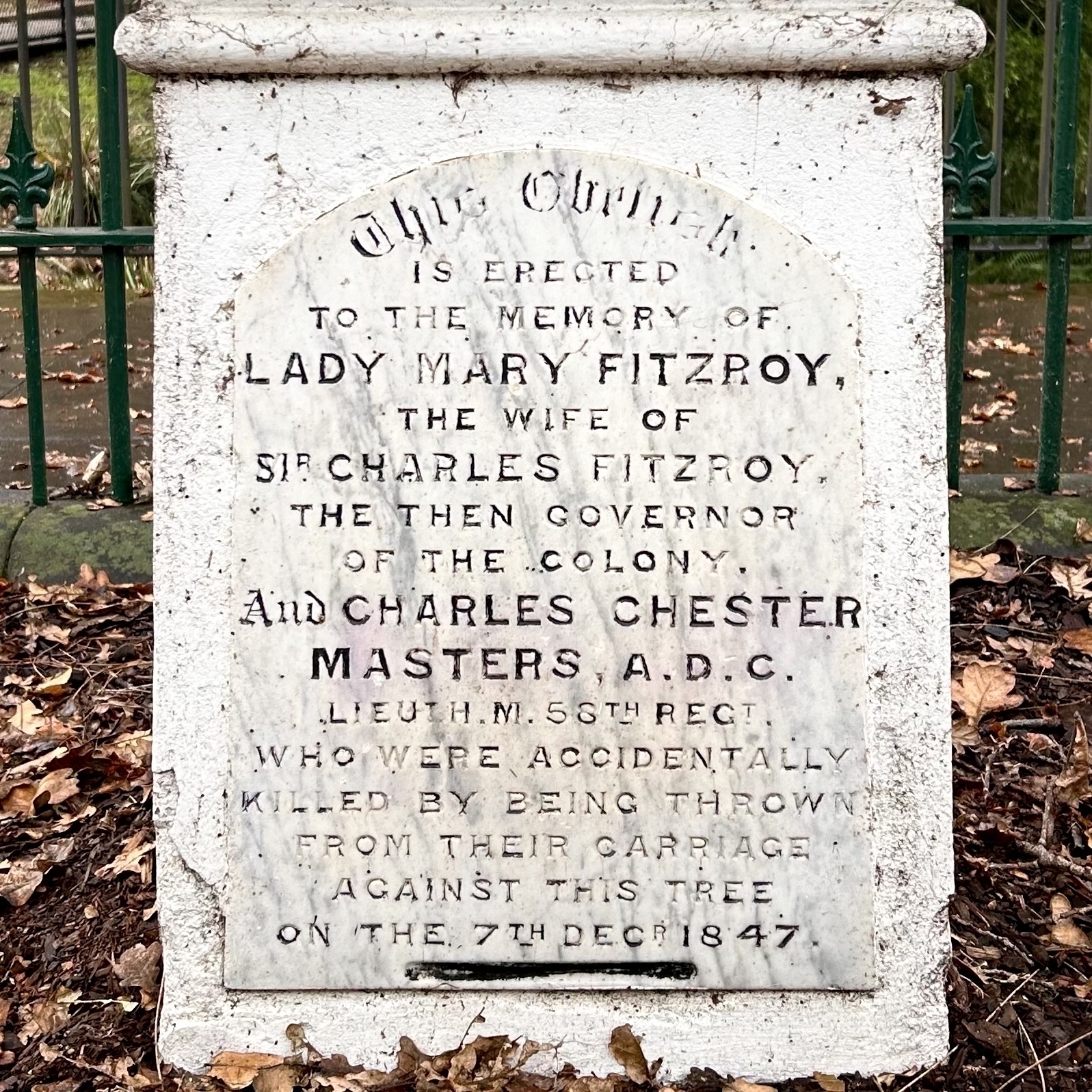 A plaque at the bottom of an obelisk. It says "THIS OBELISK IS ERECTED TO THE MEMORY OF&10;LADY MARY FITZROY, THE WIFE OFSIR CHARLES FITZROY&10;THE THEN GOVERNOR OF THE COLONY&10;AND CHARLES CHESTER MASTERS, A.D.C.&10;WHO WERE ACCIDENTALLY KILLED BYBEING THROWN FROM THEIR CARRIAGE AGAINST THIS TREE ON THE 7TH DEC I847. &10;&10;Not pictured: the tree. 