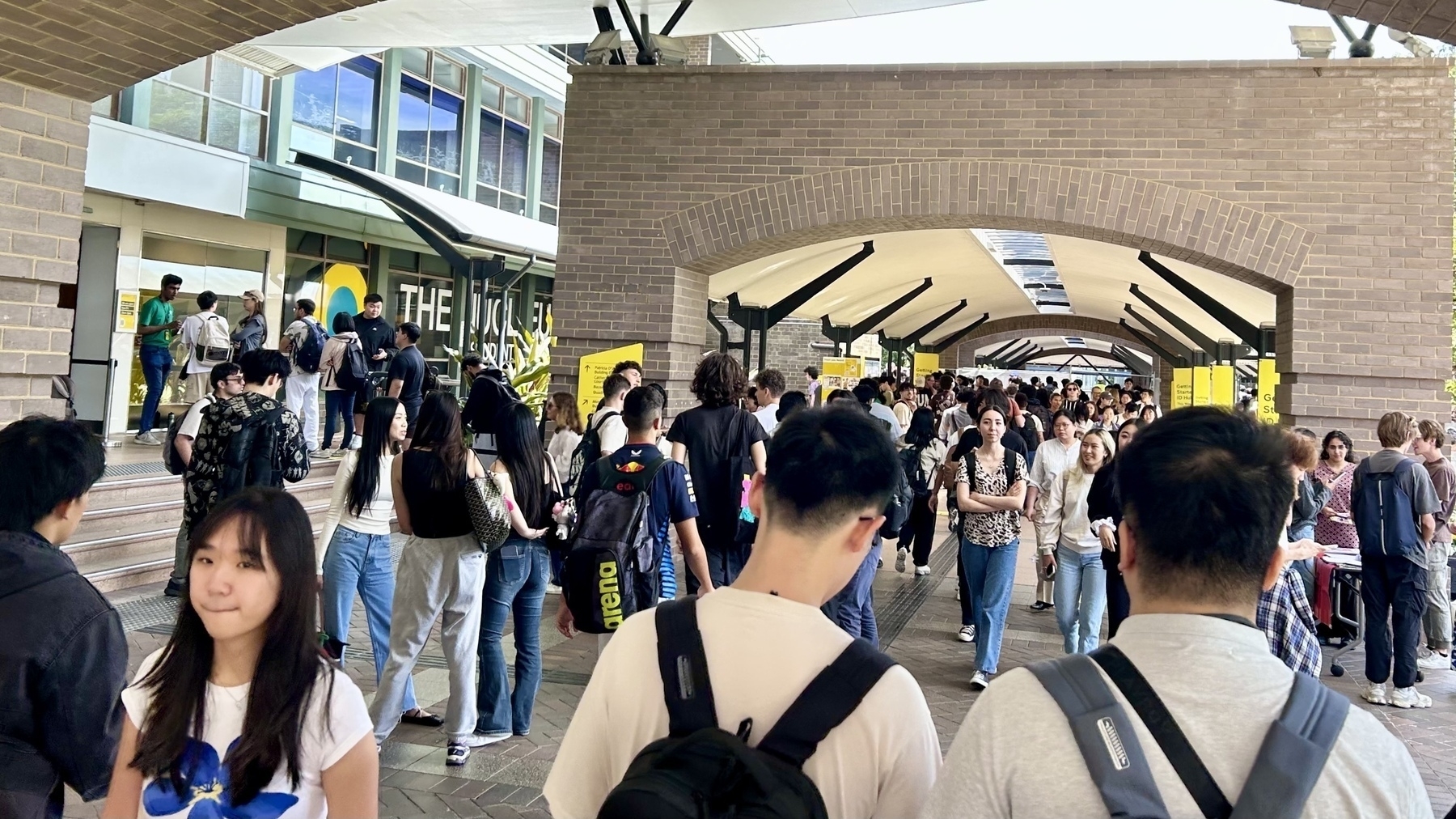 Lots of students walking past a building - it’s the UNSW library. 