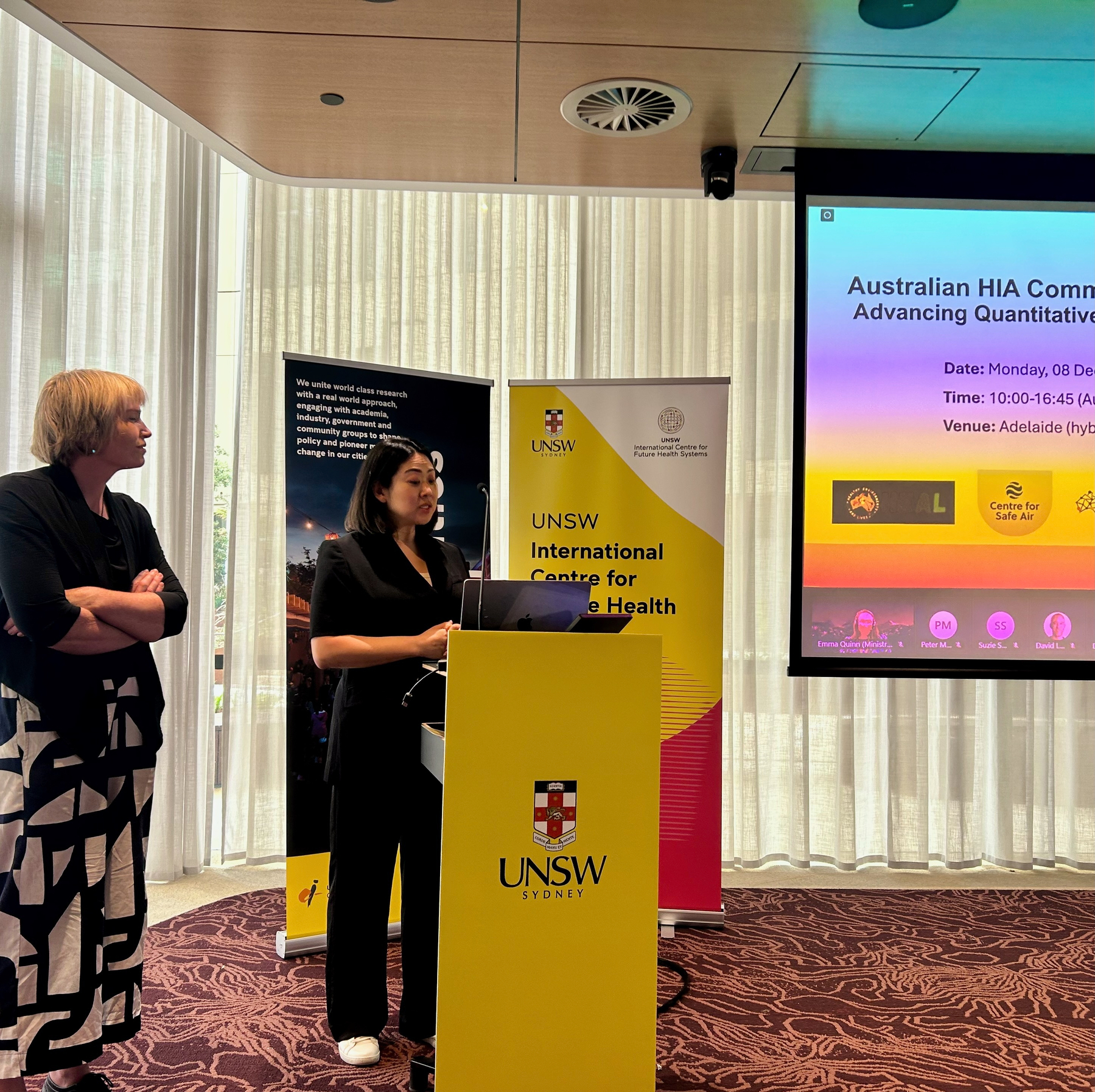 Fiona High and Jinhee Kim are at a podium presenting