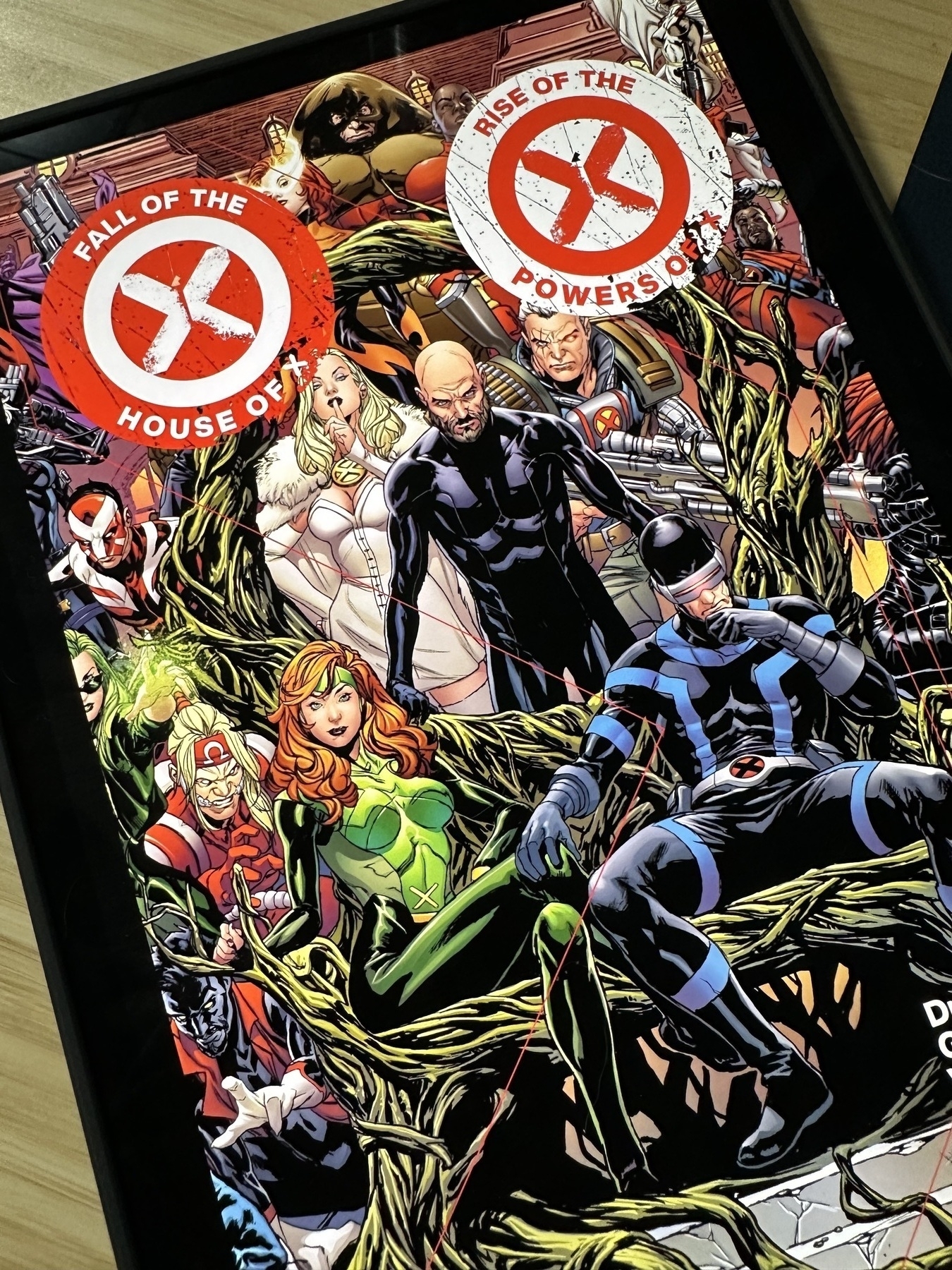 A comic book cover featuring a group of superhero characters surrounded by green vines, with prominent text reading "Fall of the House of X" and "Rise of the Powers of X."