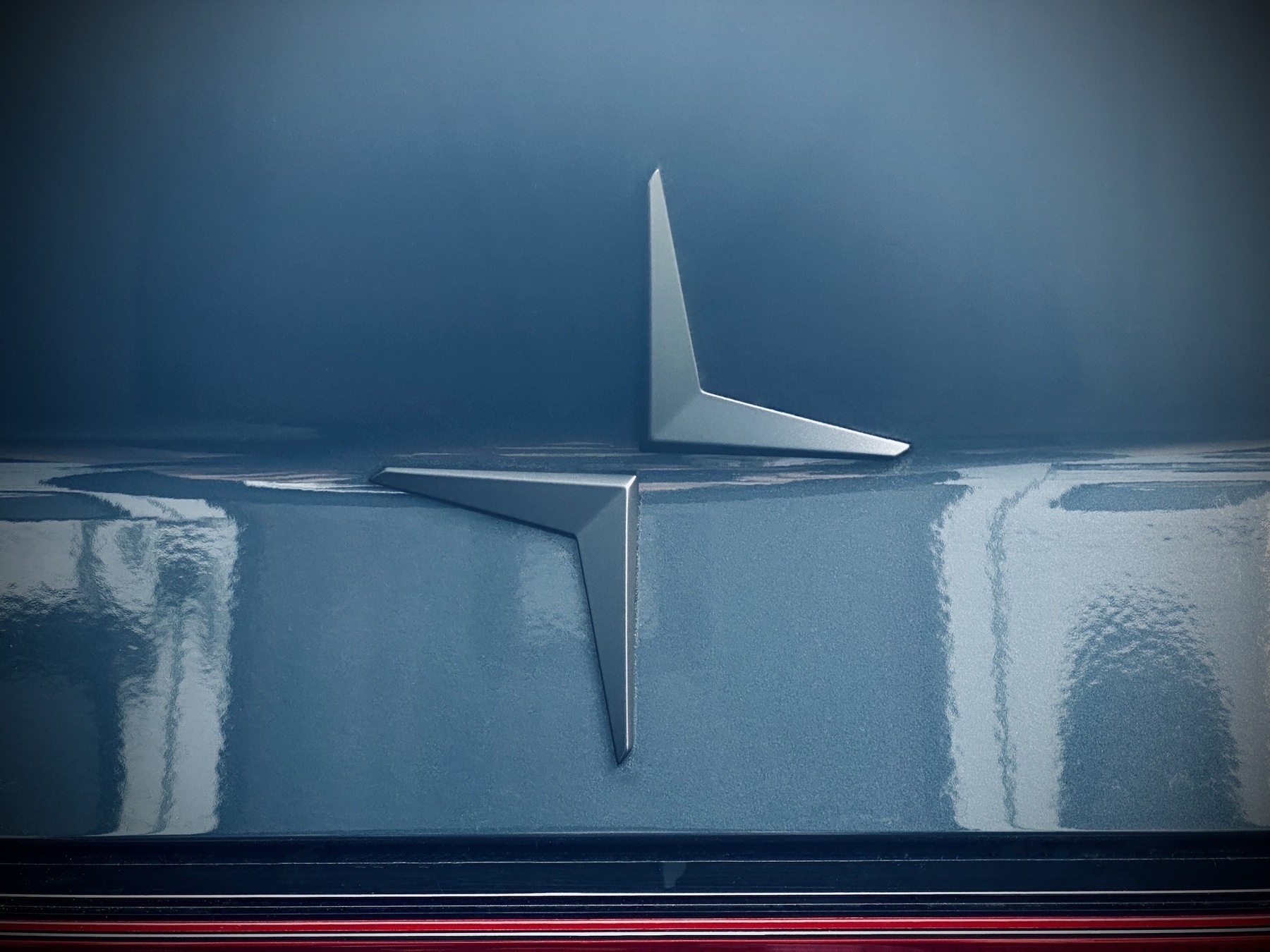 A closeup of the insignia on the back of a Midnight blue Polestar 2.