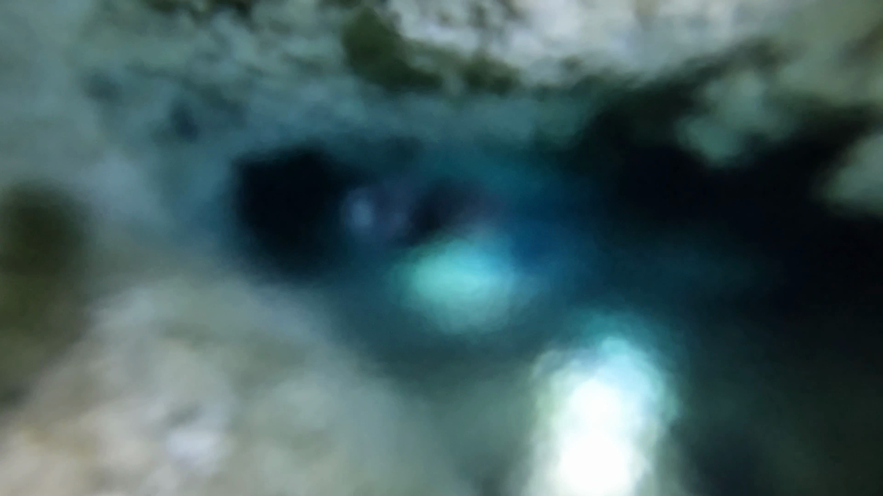 A completely blurred view of a brightly lit cave tunnel. The halocline so mixed that visibility has dropped to near zero, like looking through a deeply defocused camera lens.