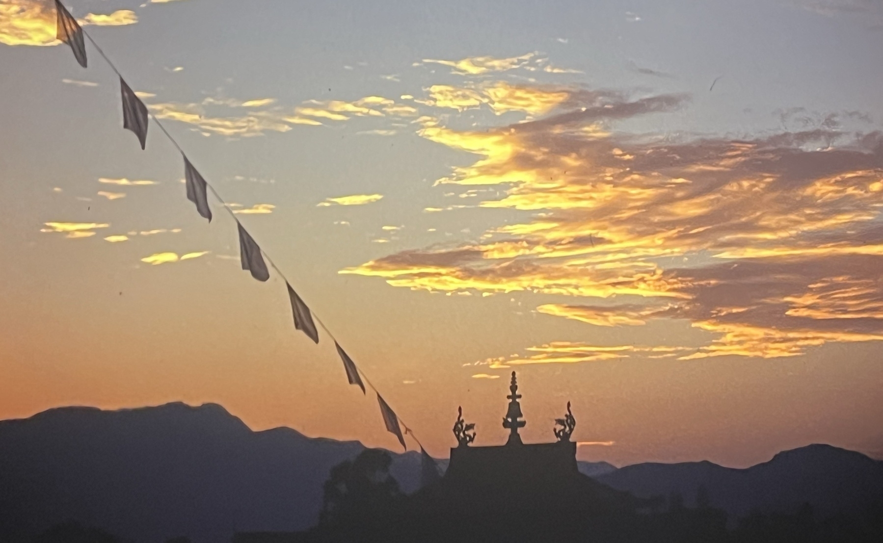Sunset over a Tibetan monastery with prayer flags near Kathmandu Nepal