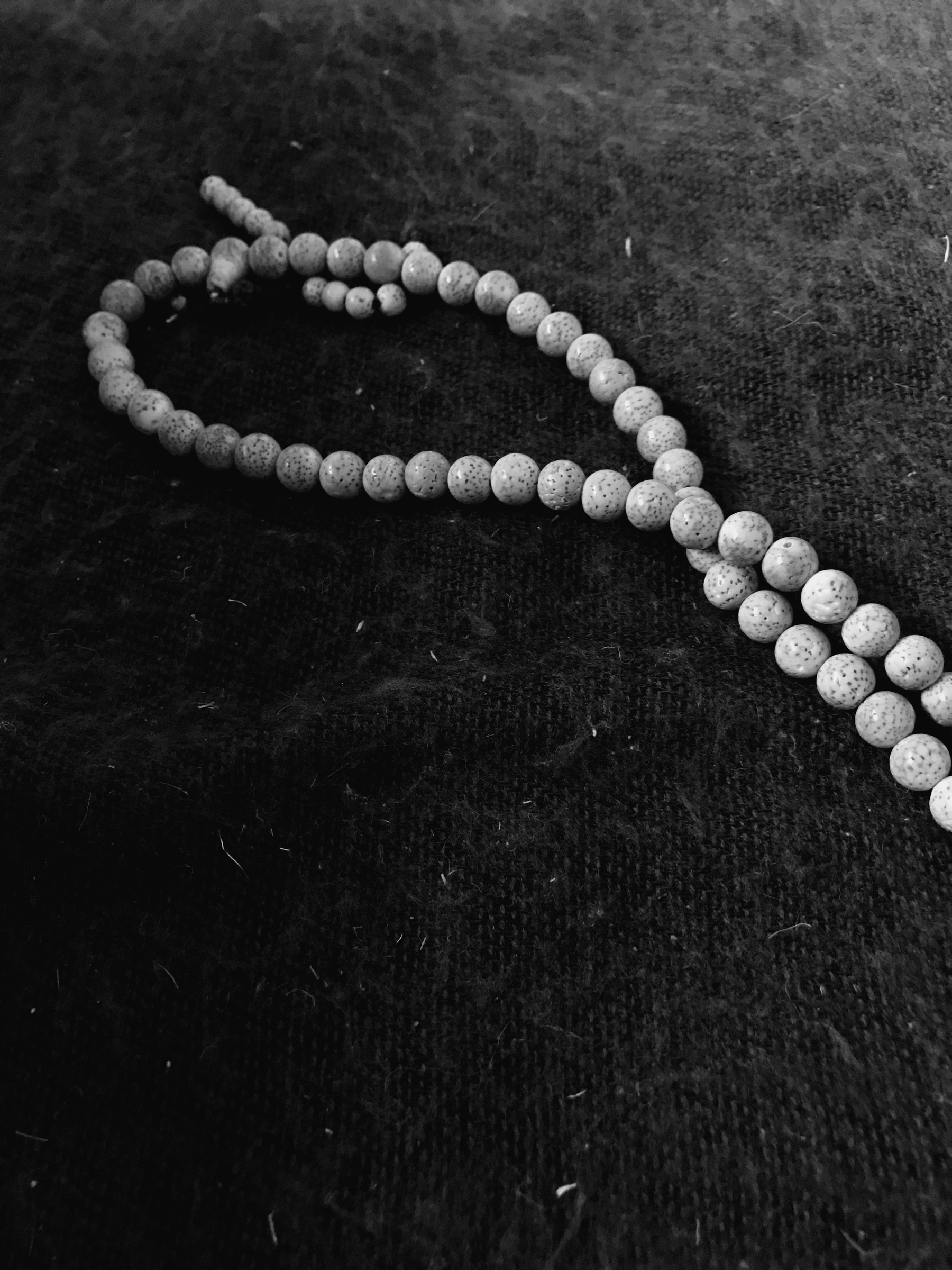 A black and white photograph of my old mala (rosary) on a blanket