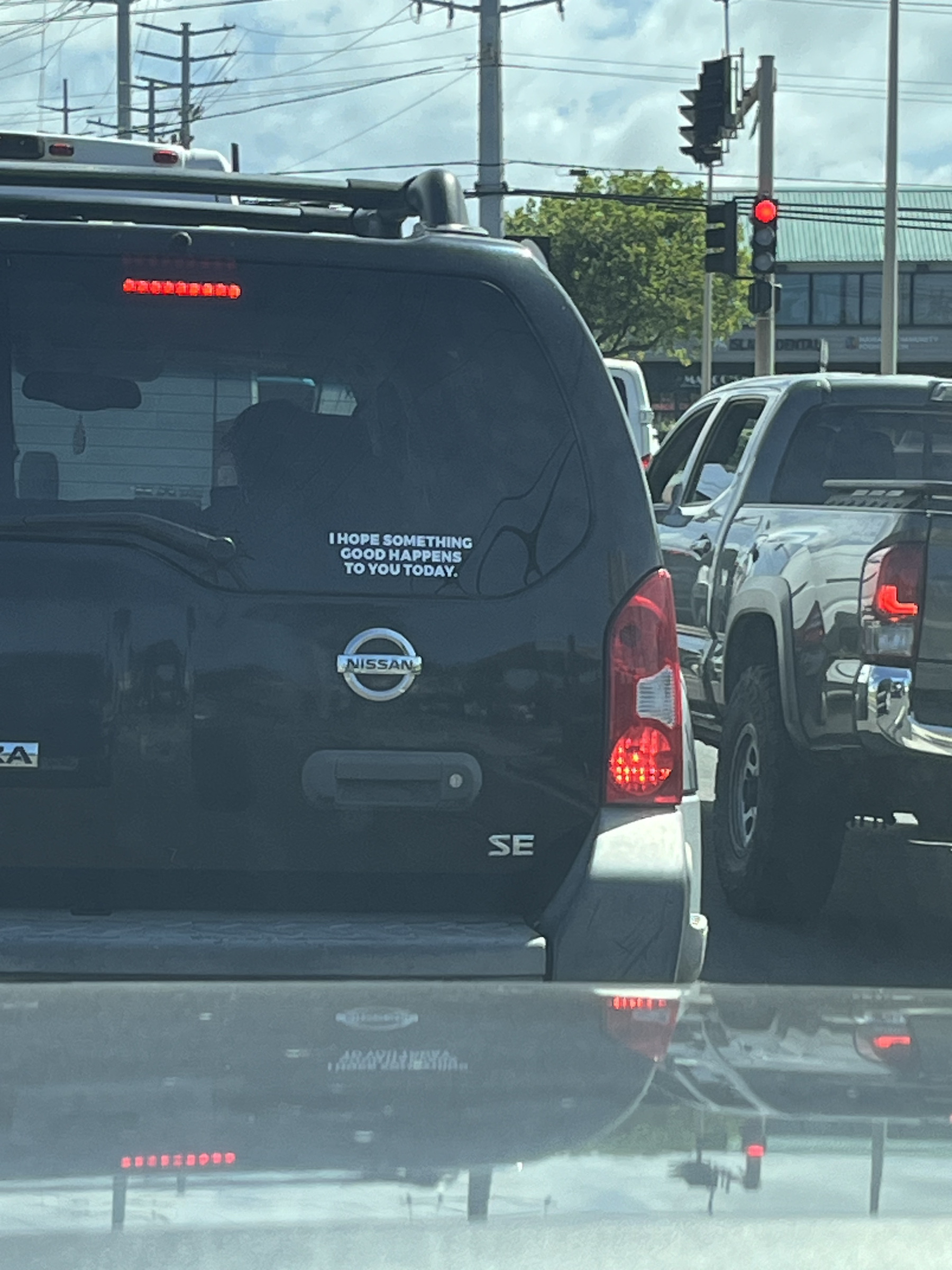 Auto generated description: A Nissan car has a sticker on its rear window that reads, “I hope something good happens to you today.