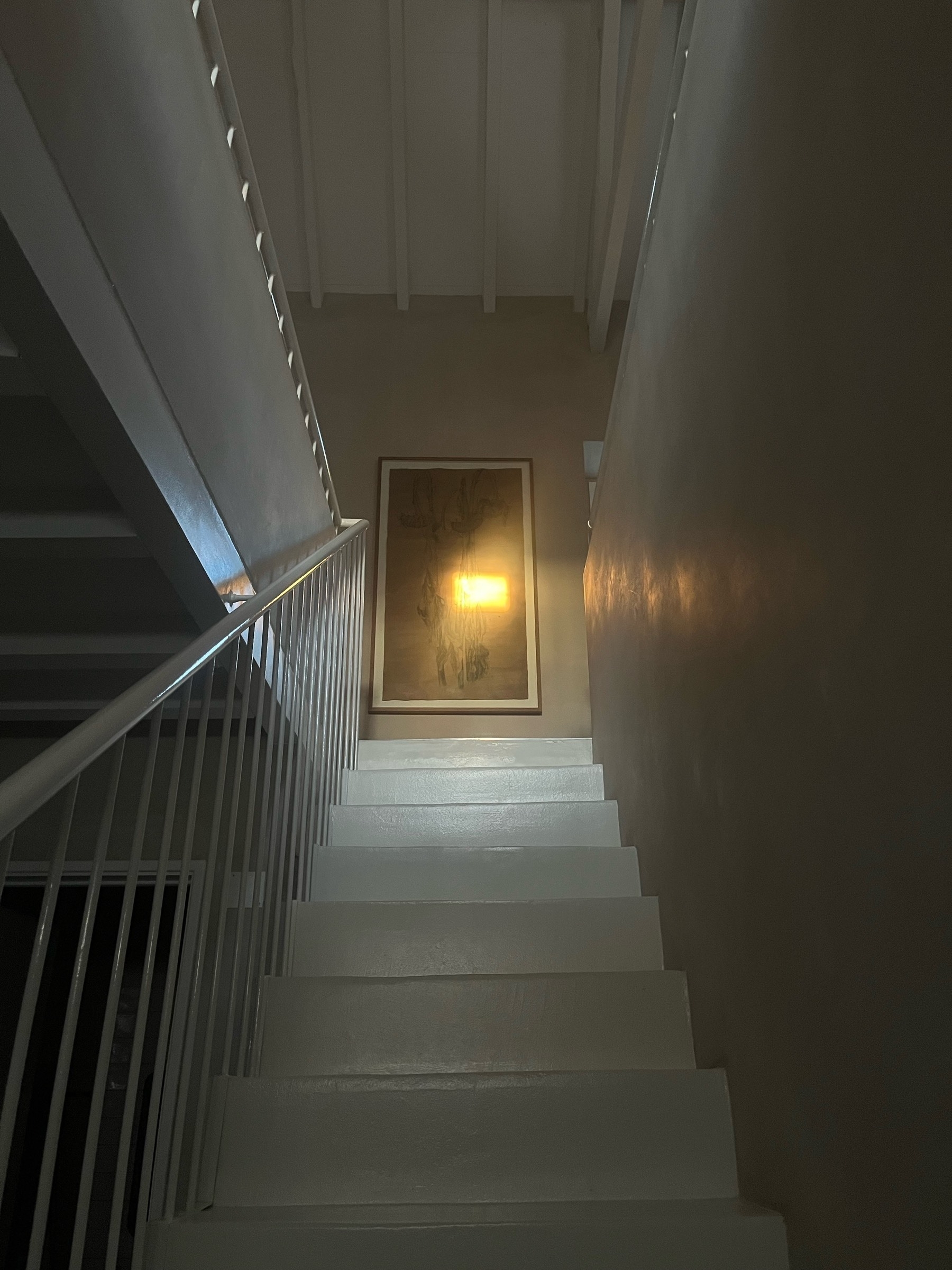 Sunlight strikes a pairing hanging at the top of some stairs, creating a rectangular shape of light.