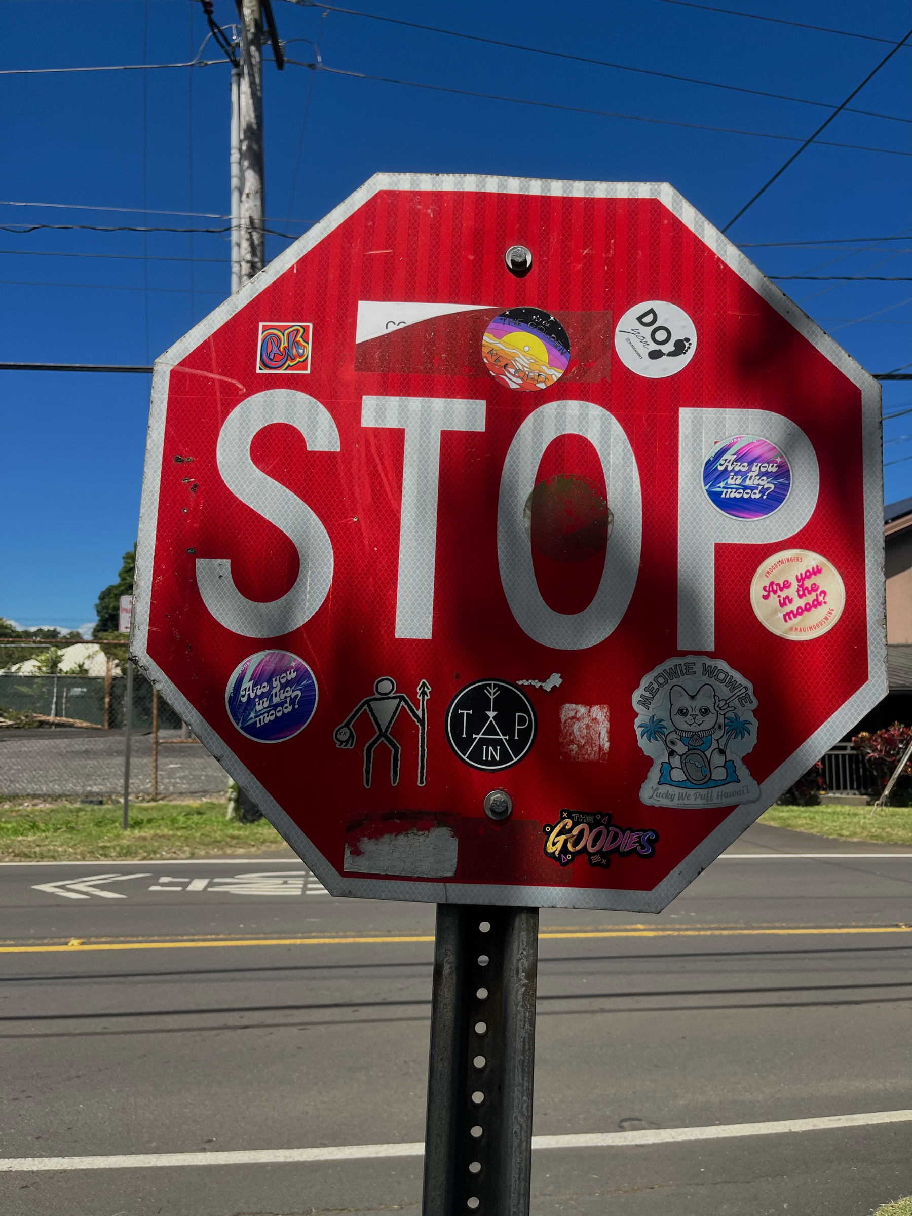 A STOP sign covered in stickers. STOP is still visible. 