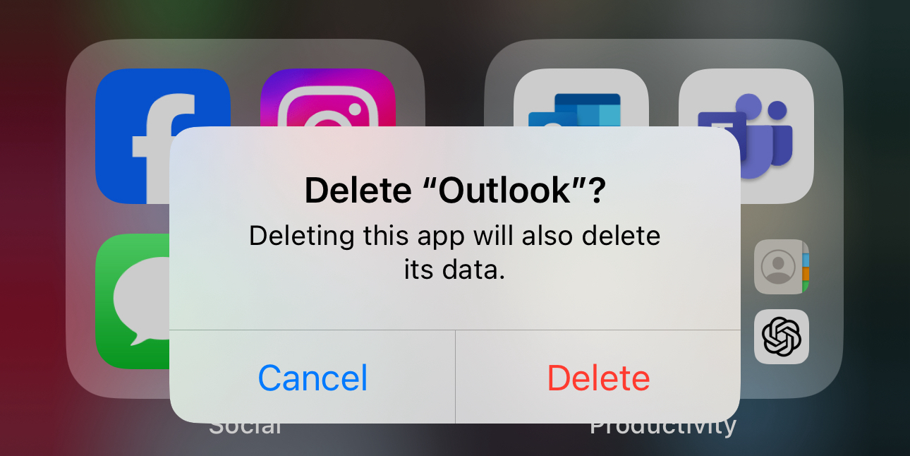 An on-screen prompt asking to confirm the deletion of the “Outlook” app, with a warning that deleting the app will also delete its data. The options “Cancel” and “Delete” are available at the bottom. In the background, blurred