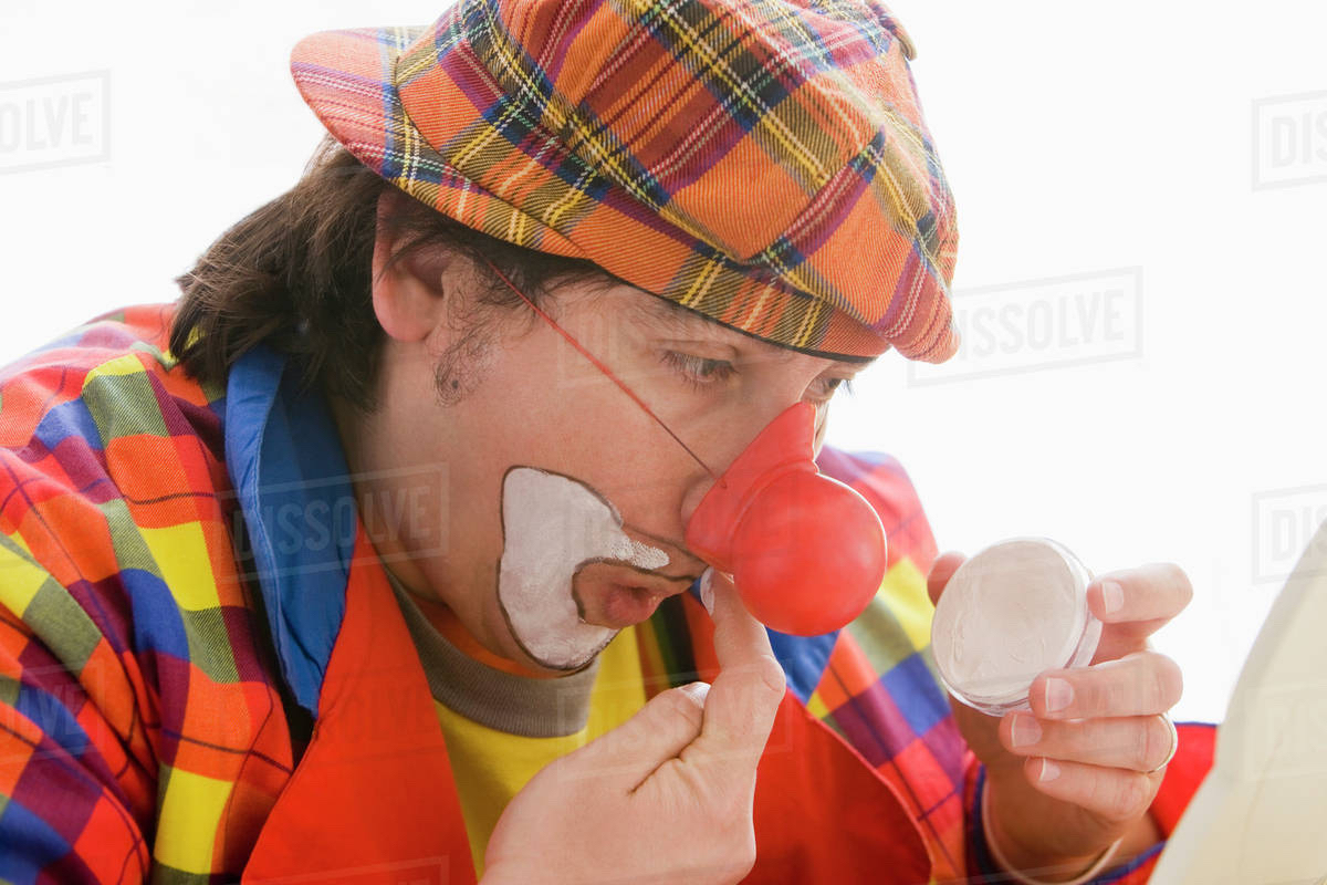 Man putting on clown make up