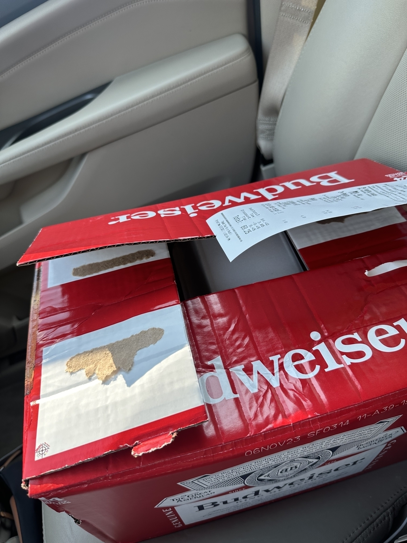 Budweiser beer bottle box re-used as takeout box. Receipt on top. 