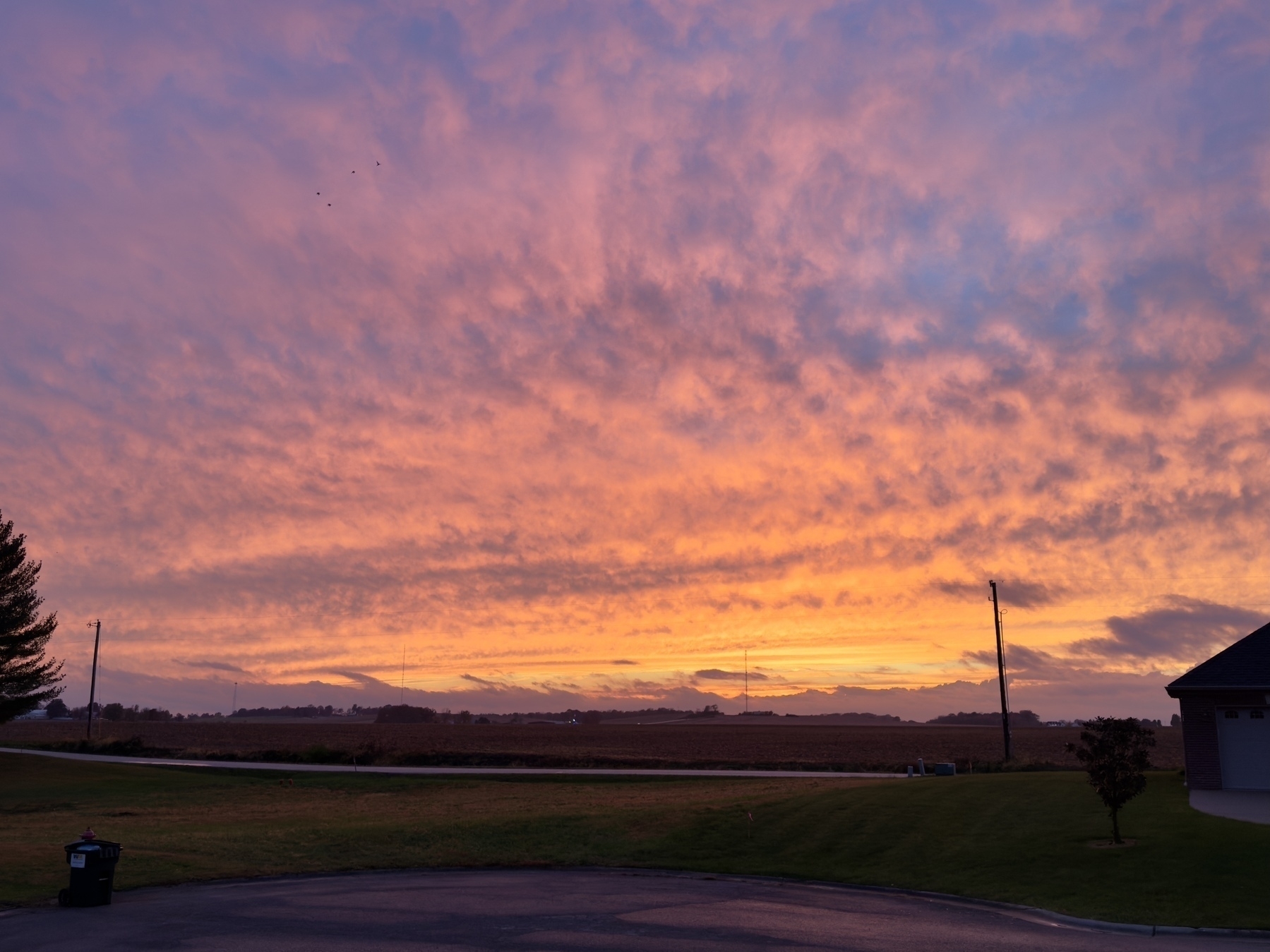 A stunning sunset casts a warm glow over a serene landscape, with soft clouds painted in shades of pink and orange.