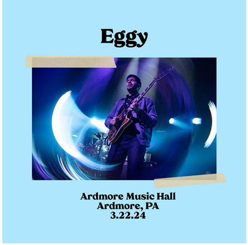 A promotional poster featuring a guitarist on stage with text indicating a performance by “Eggy” at Ardmore Music Hall in Ardmore, PA on March 22, 2024. The image has a blue background with two pieces of tape graphics