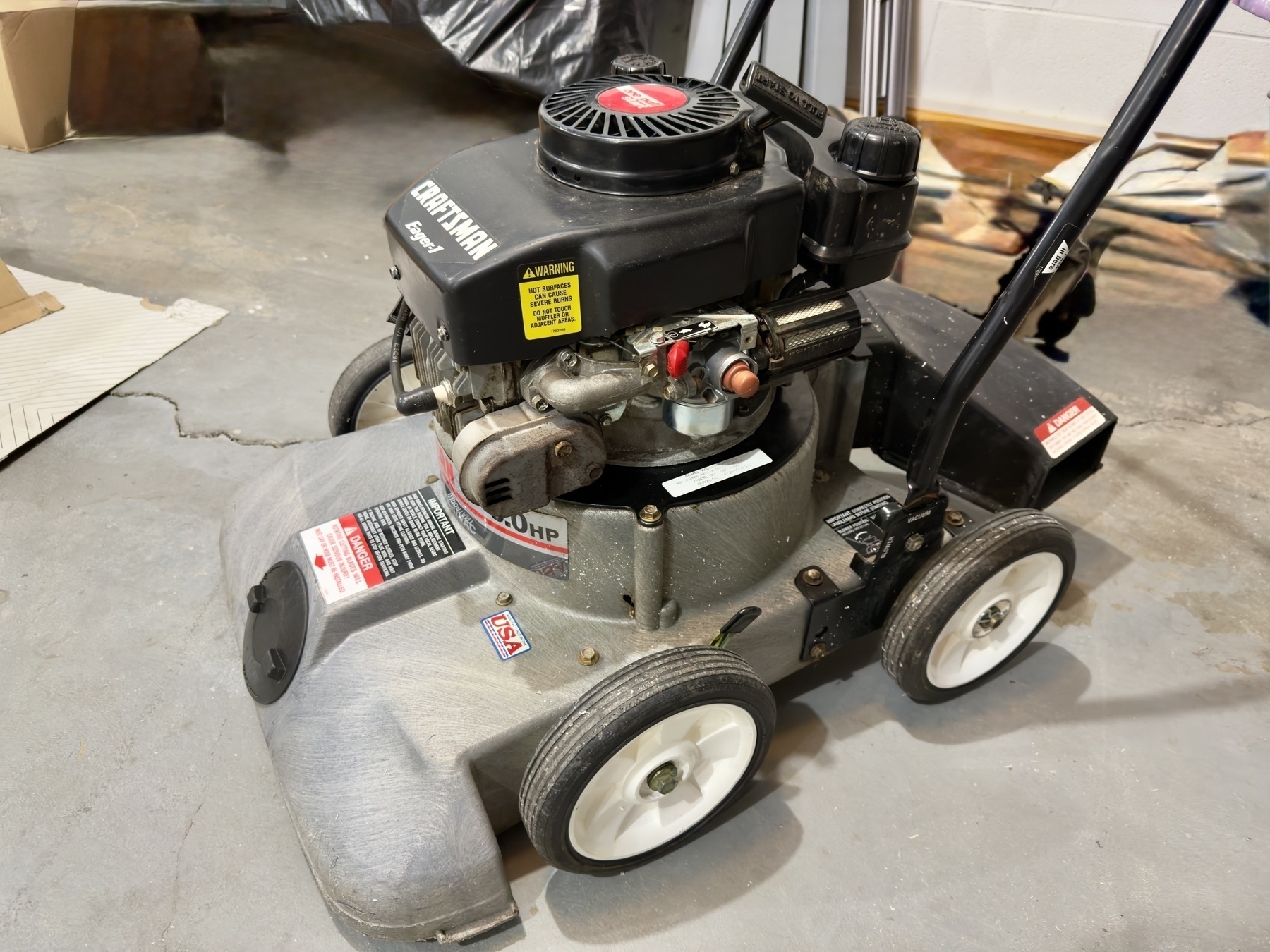 A Craftsman gas-powered lawn vacuum is positioned on a concrete floor.