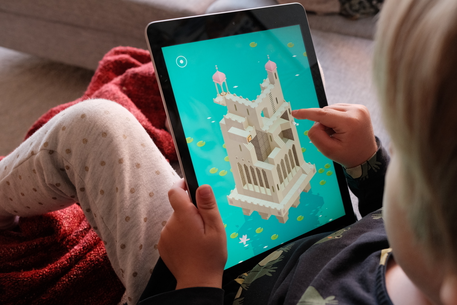 Pojke som sitter med sin iPad och klurar i spelet Monument Valley