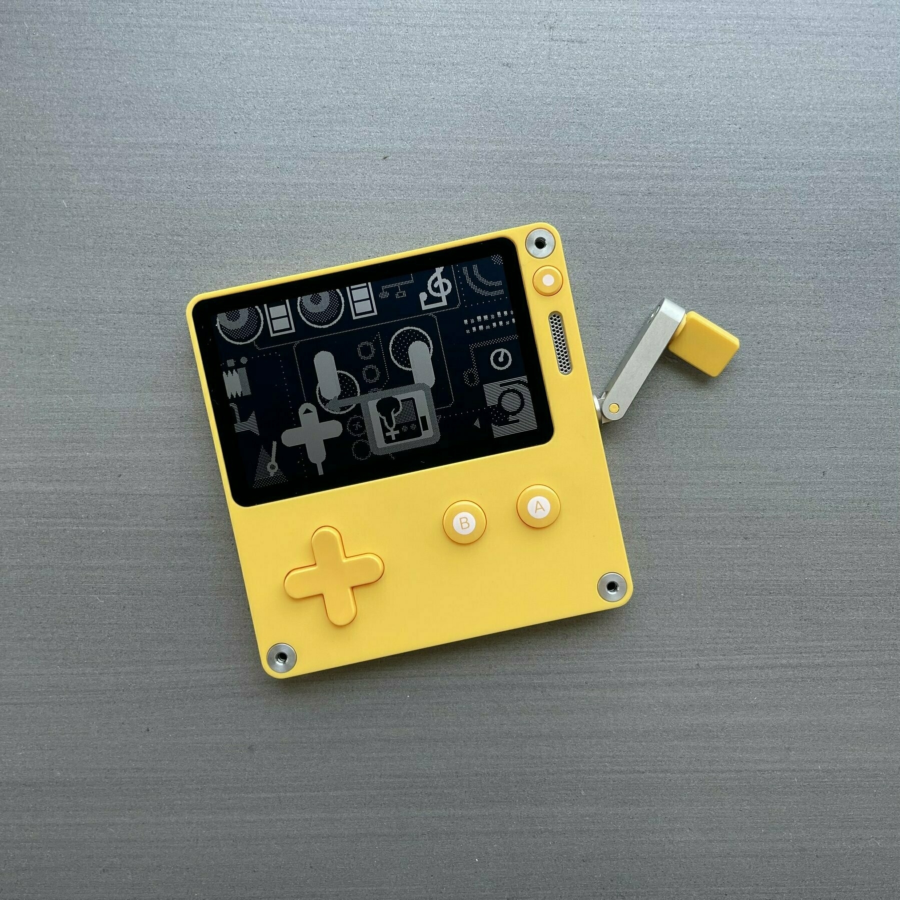 Photo of a Playdate hand-held console.
