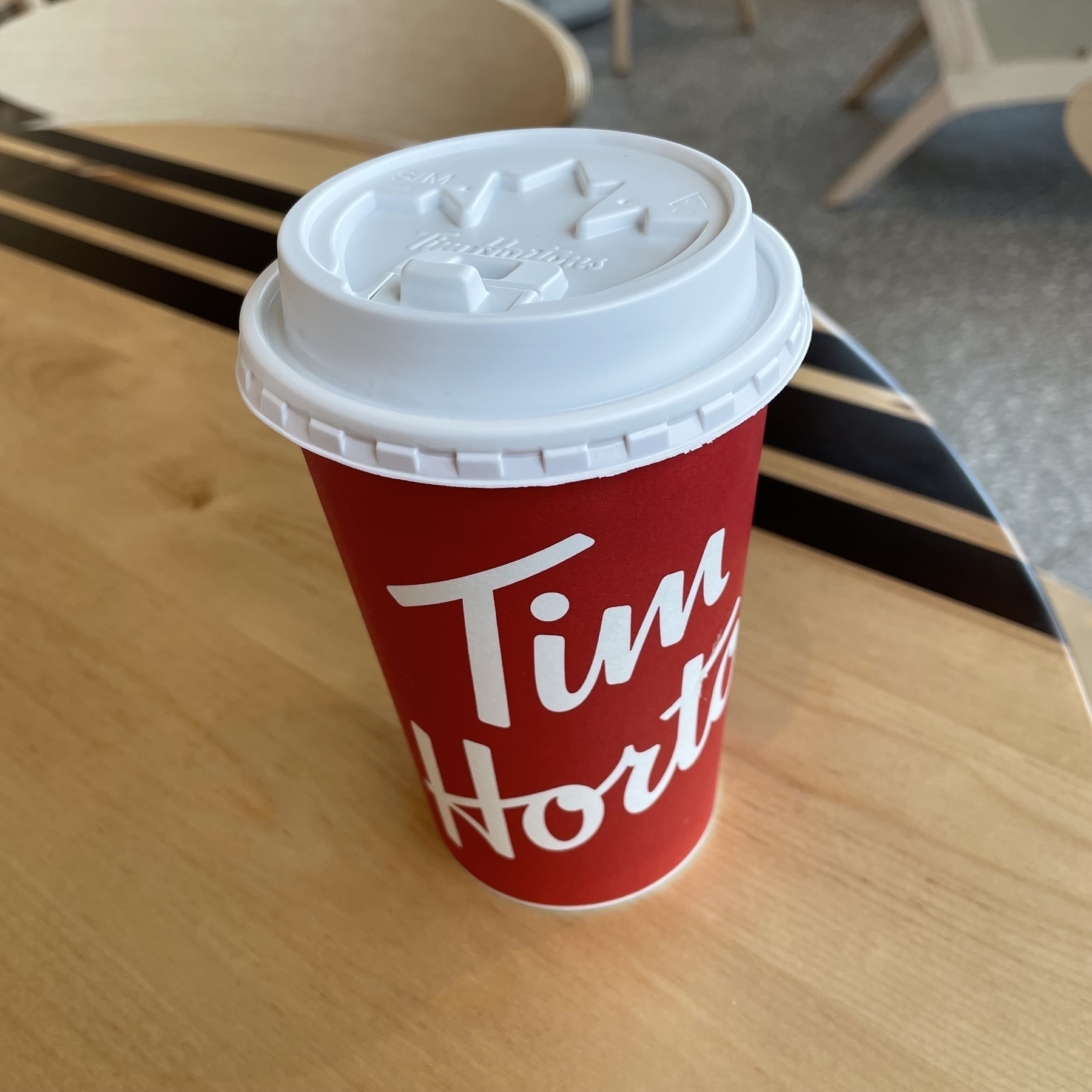 Picture of a Tim Hortons coffee cup on a table. 