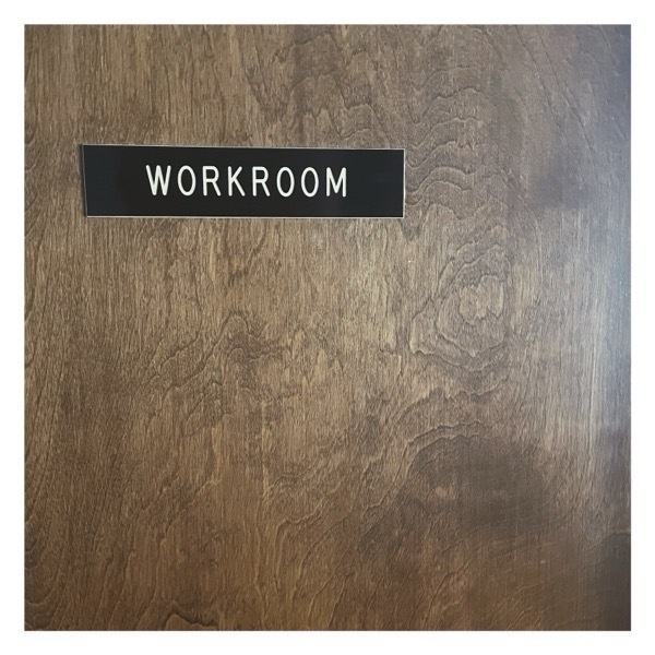Workroom sign on a wooden door.