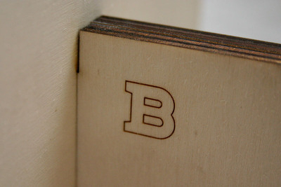 A close-up of the laser burning, The edges are darker from the laser cutting. The “B” is burned in at medium strength.