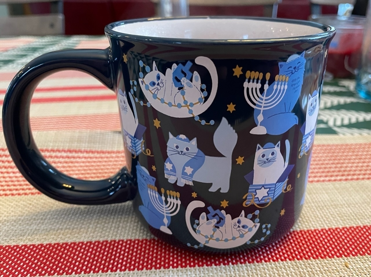 Mug with happy cats wearing Jewish clothing surrounded by menorahs.