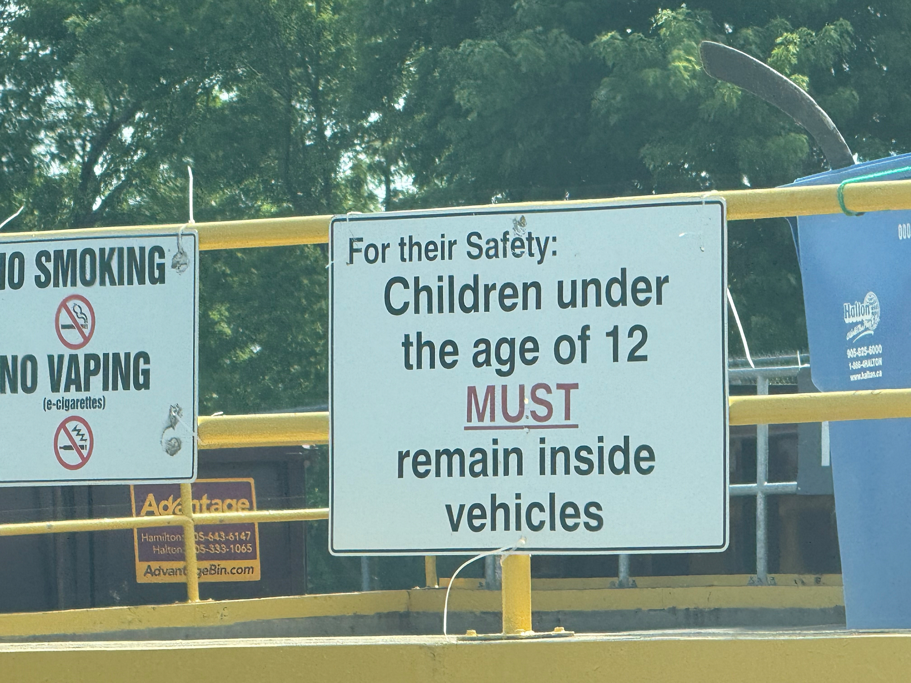 Signs indicate that children under the age of 12 must remain inside vehicles for their safety.