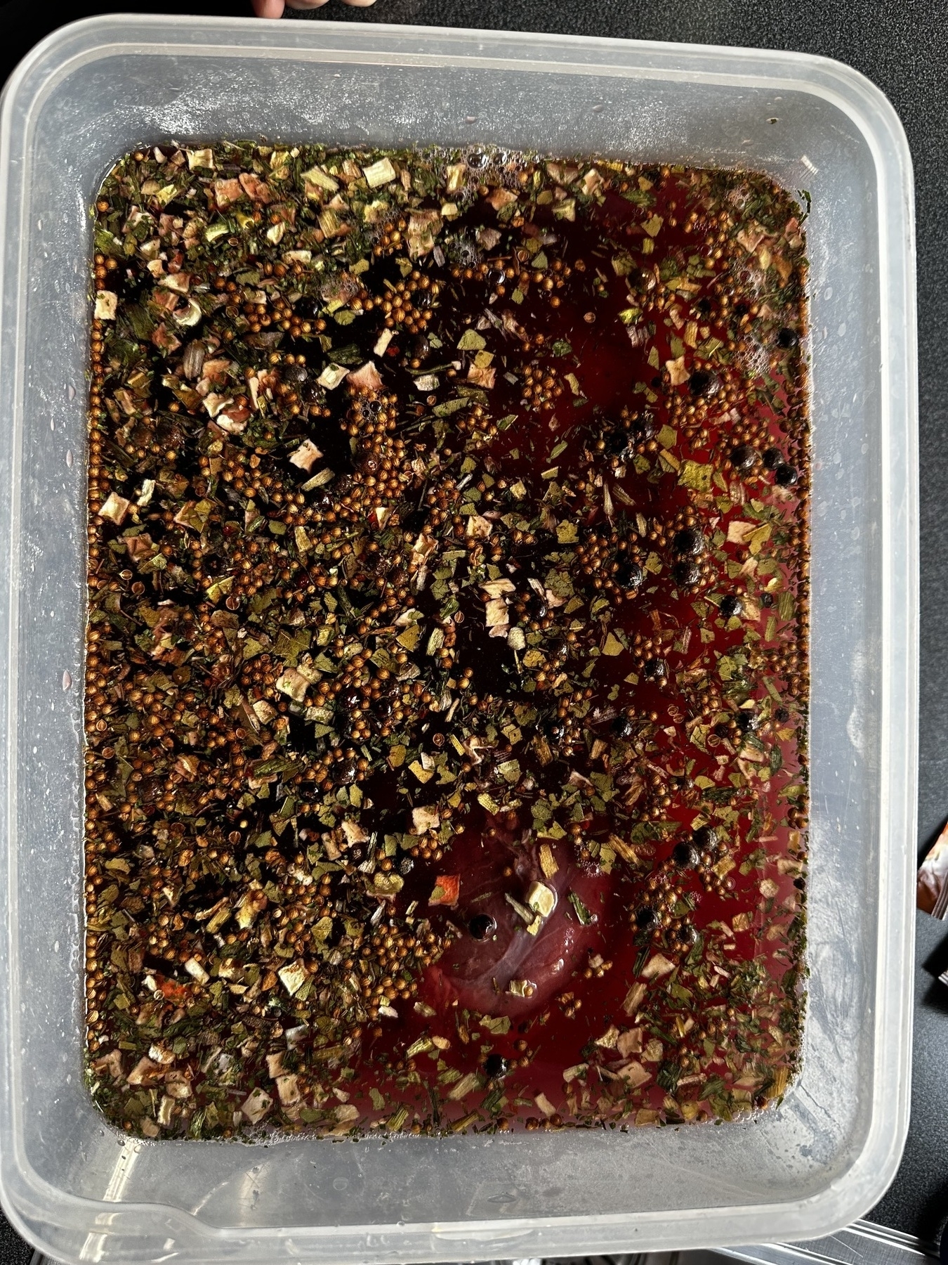 Beef in Sauerbraten marinade, spices floating on the surface