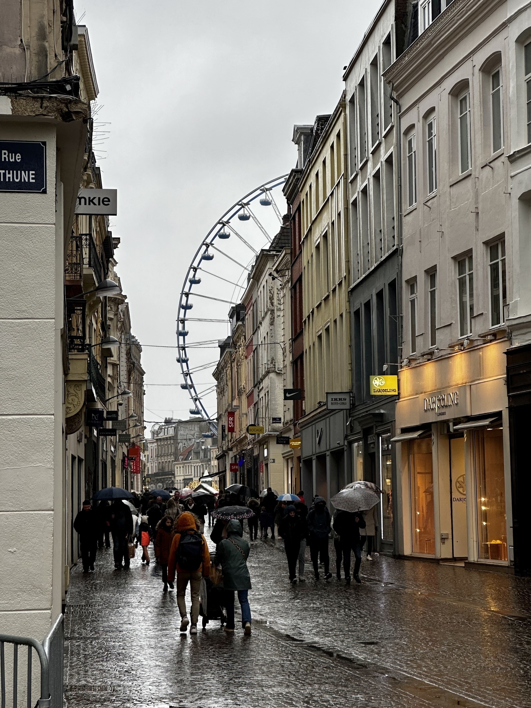 View of a Grande roue on the Grand Place from a side street in the rain