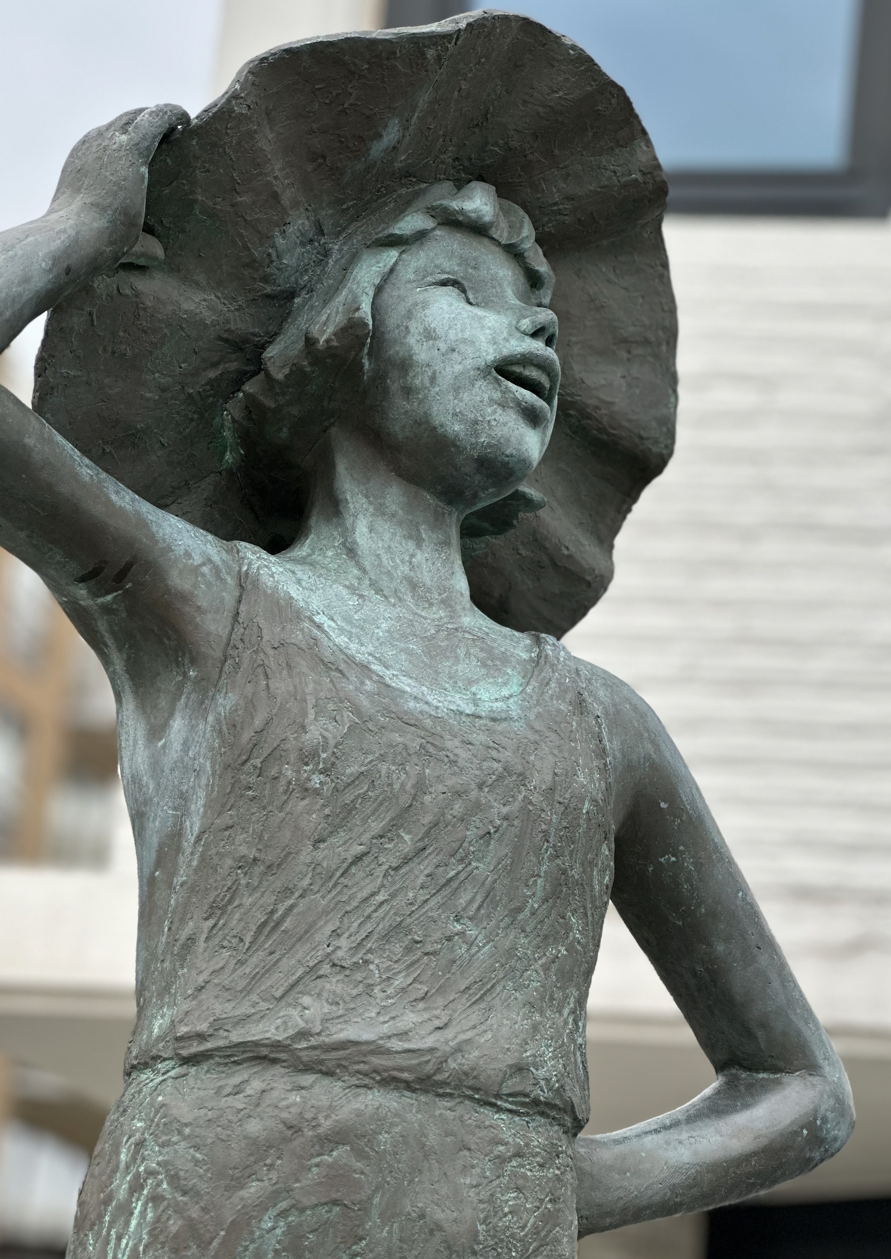 Bronze of a girl with a wide hat, happy with the view