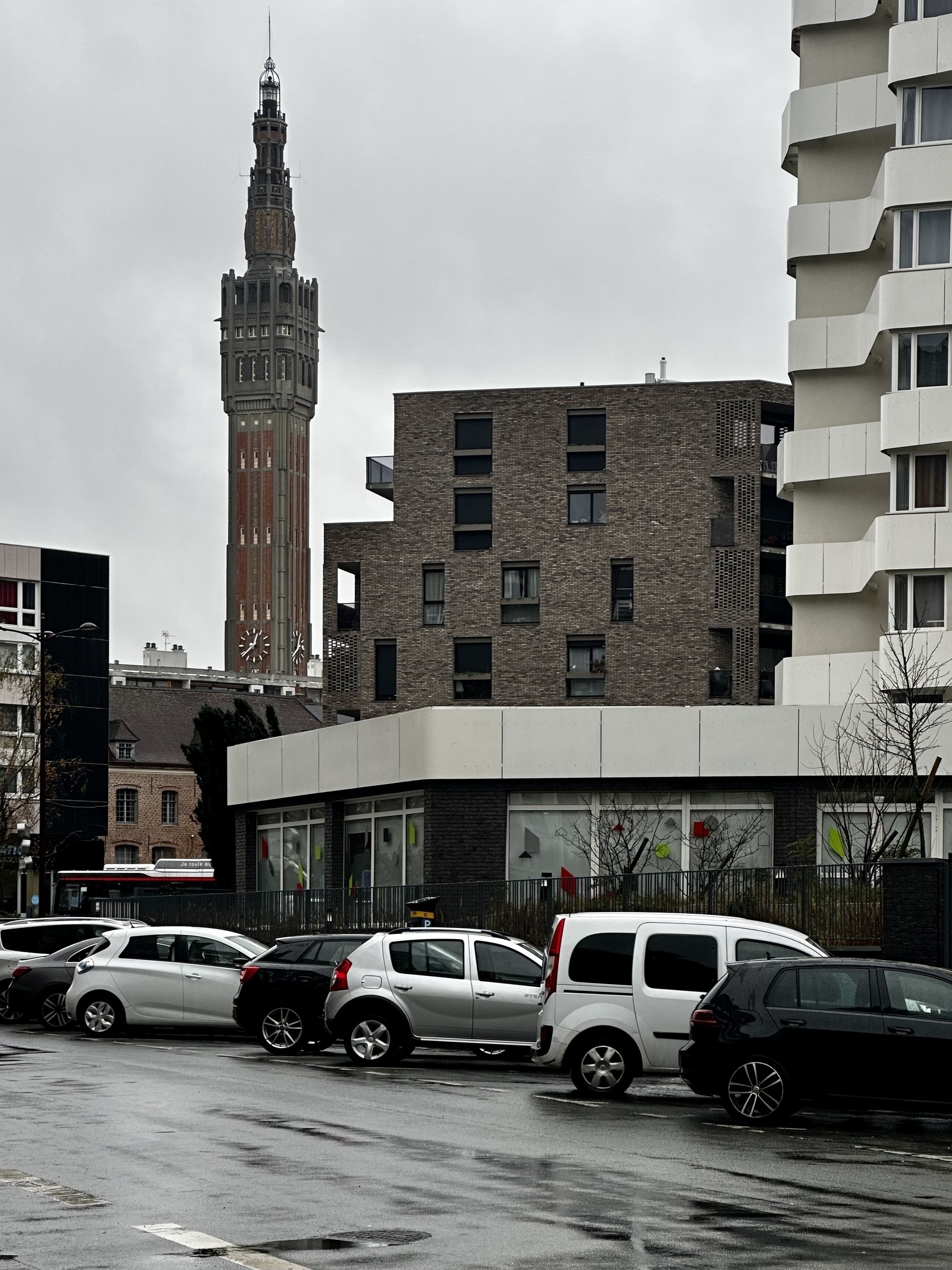 Belfry in the rainy distance, framed by brutalist buildings