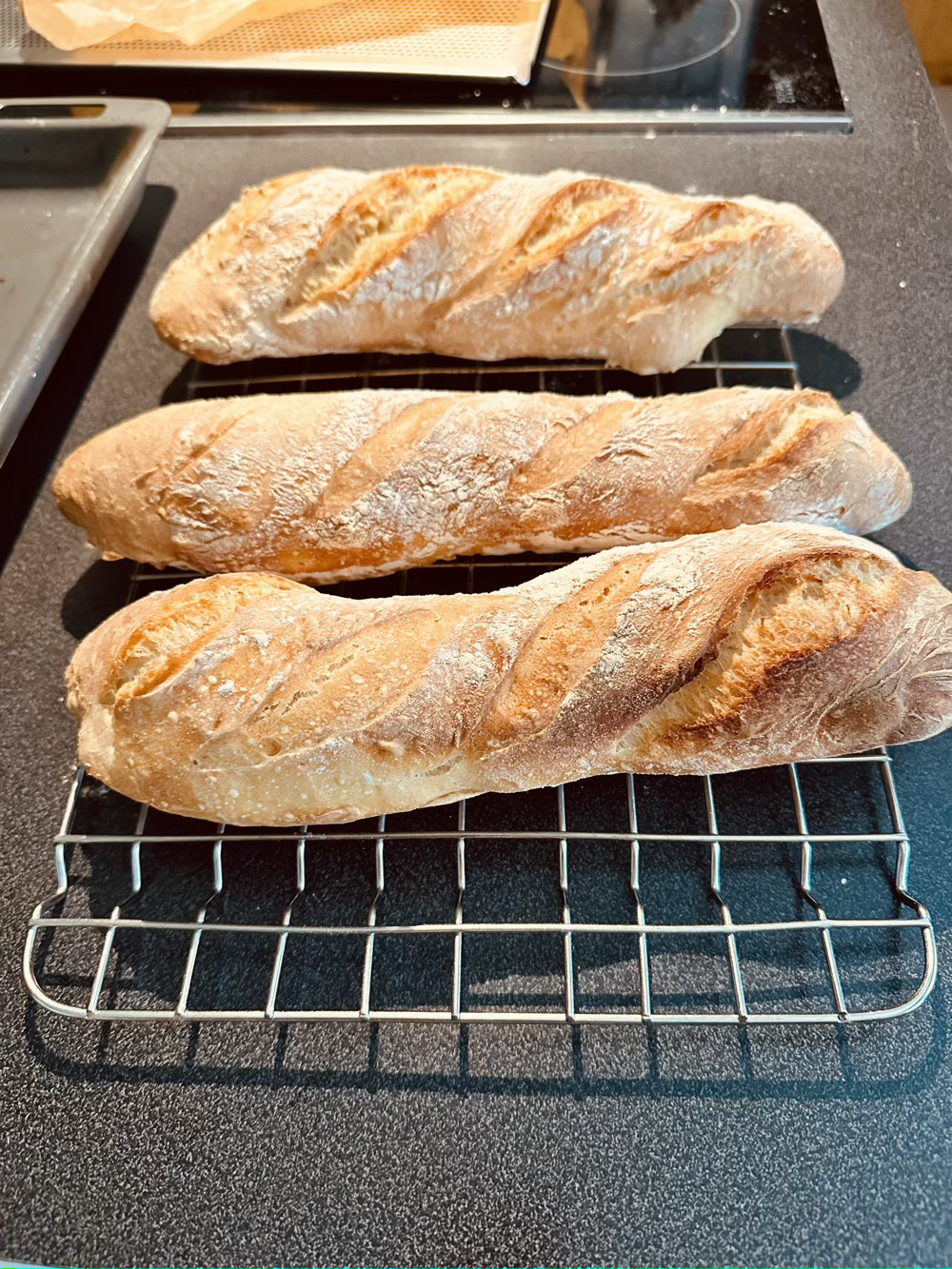 3 homemade baguettes on cooling rack