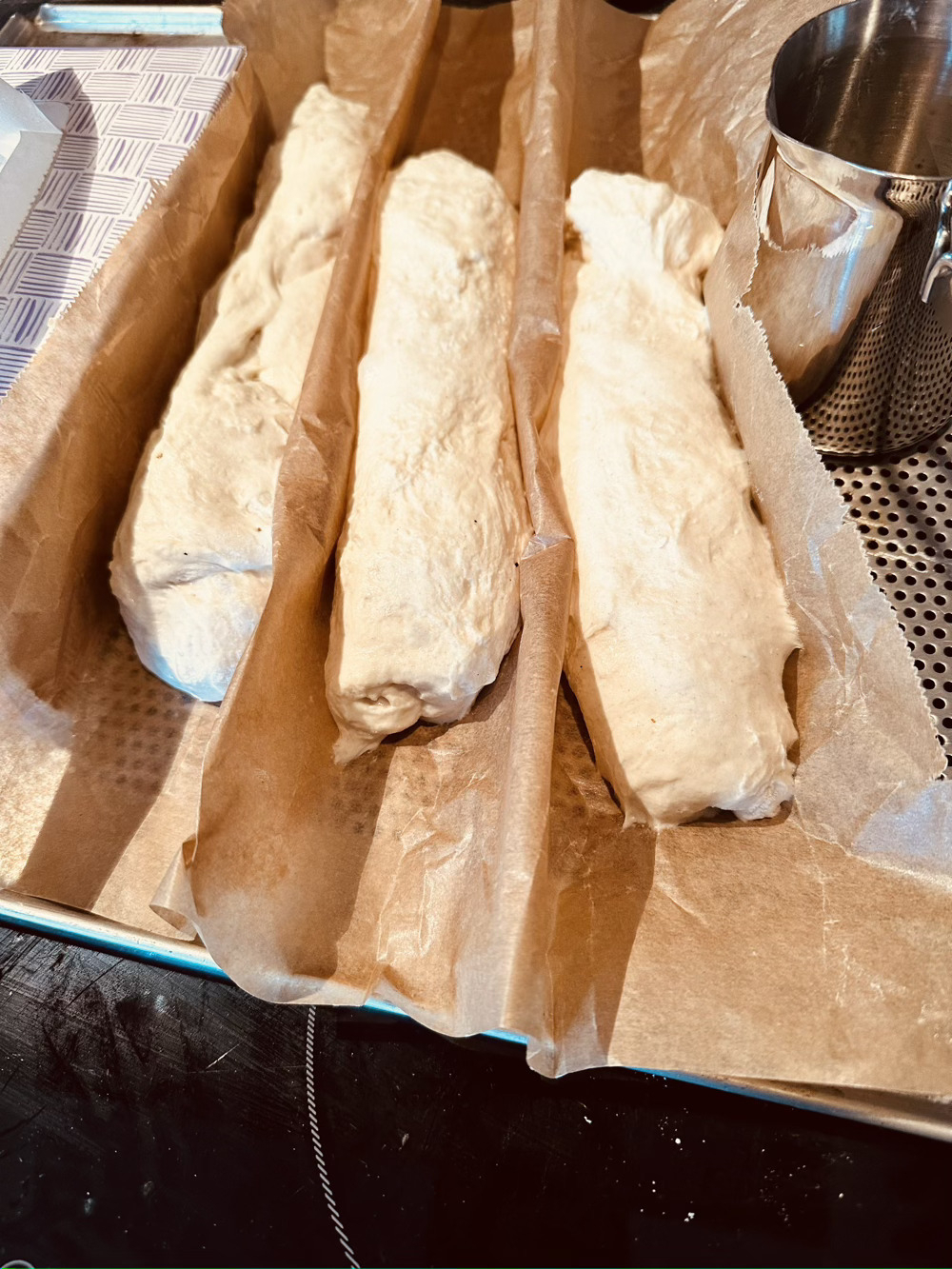 3 shaped baguettes resting between folds of baking parchment 