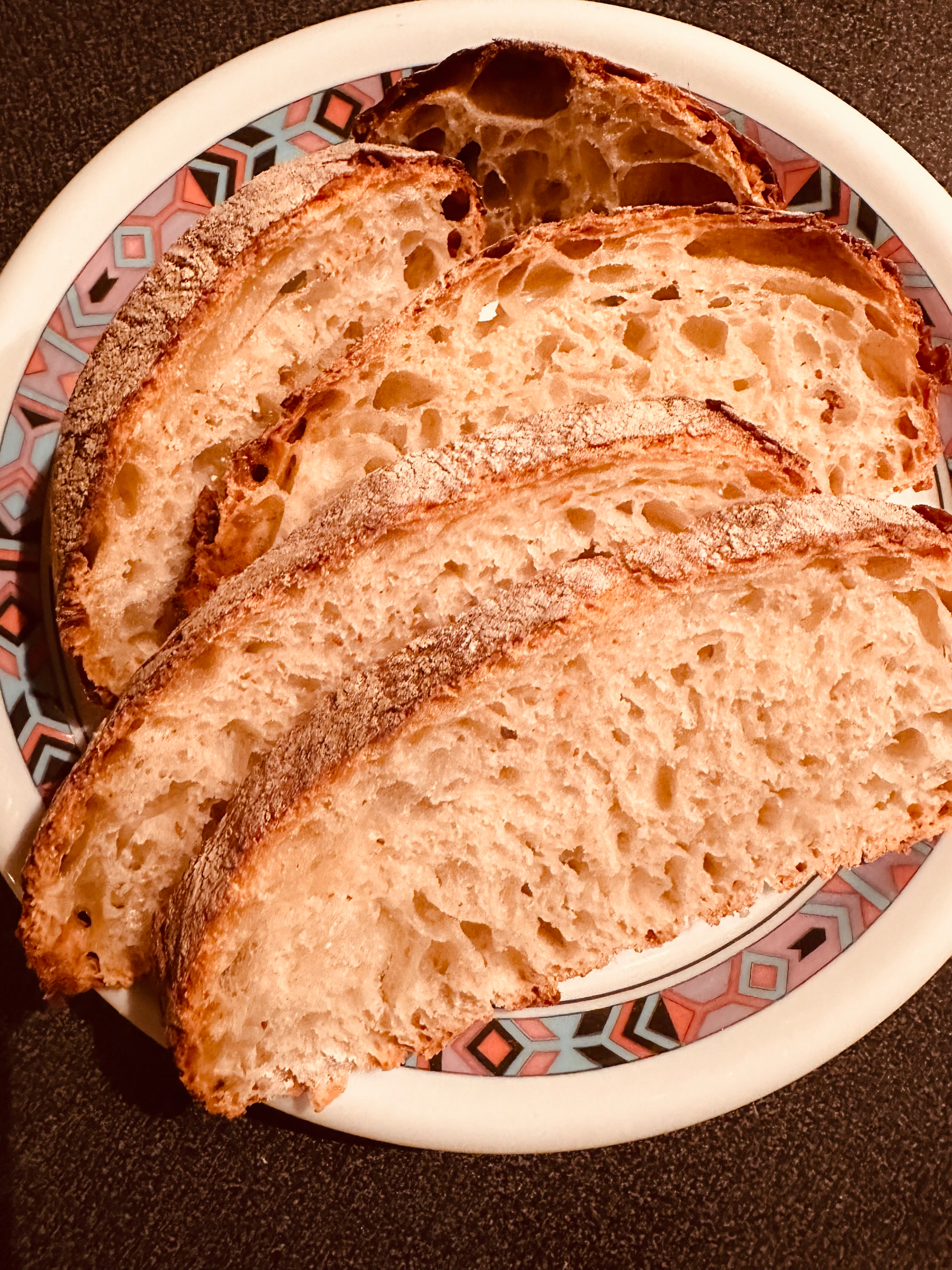 Several slices of crusty ciabatta are arranged on a plate.
