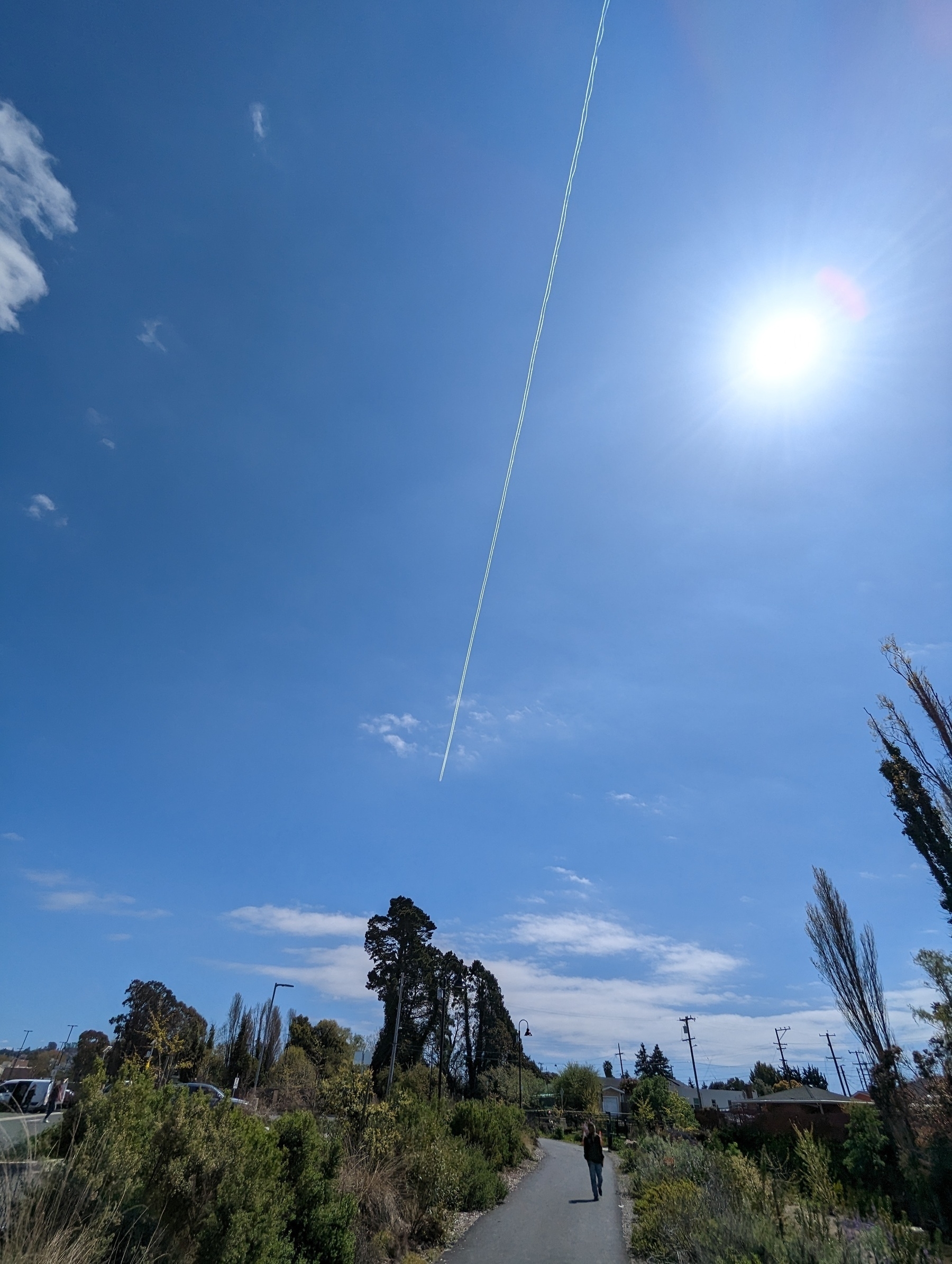 A long thin high white contrail left by a Cathay Pacific flight from Hong Kong bound for Los Angeles international airport stretches out against sunny blue skies Saturday, April 1, 2023 in San Pablo, California.
