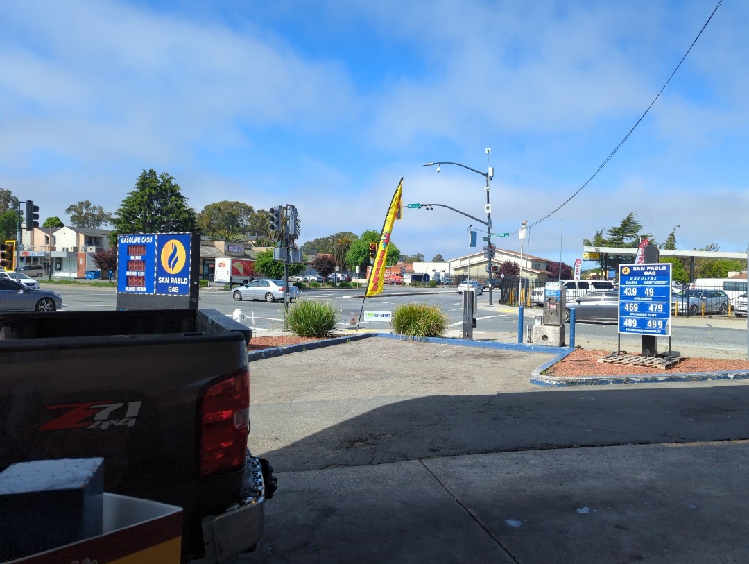 A view of the intersection of El Portal Road where Church Lane becomes Rollingwood from the San Pablo Gas station Friday, May 20, 2023 in San Pablo, California. Under the shade of the station roof, low gray stratus bands hang in sunny blue skies, and a sign says the cheapest grade of unleaded gas sells for $4.39 a gallon.