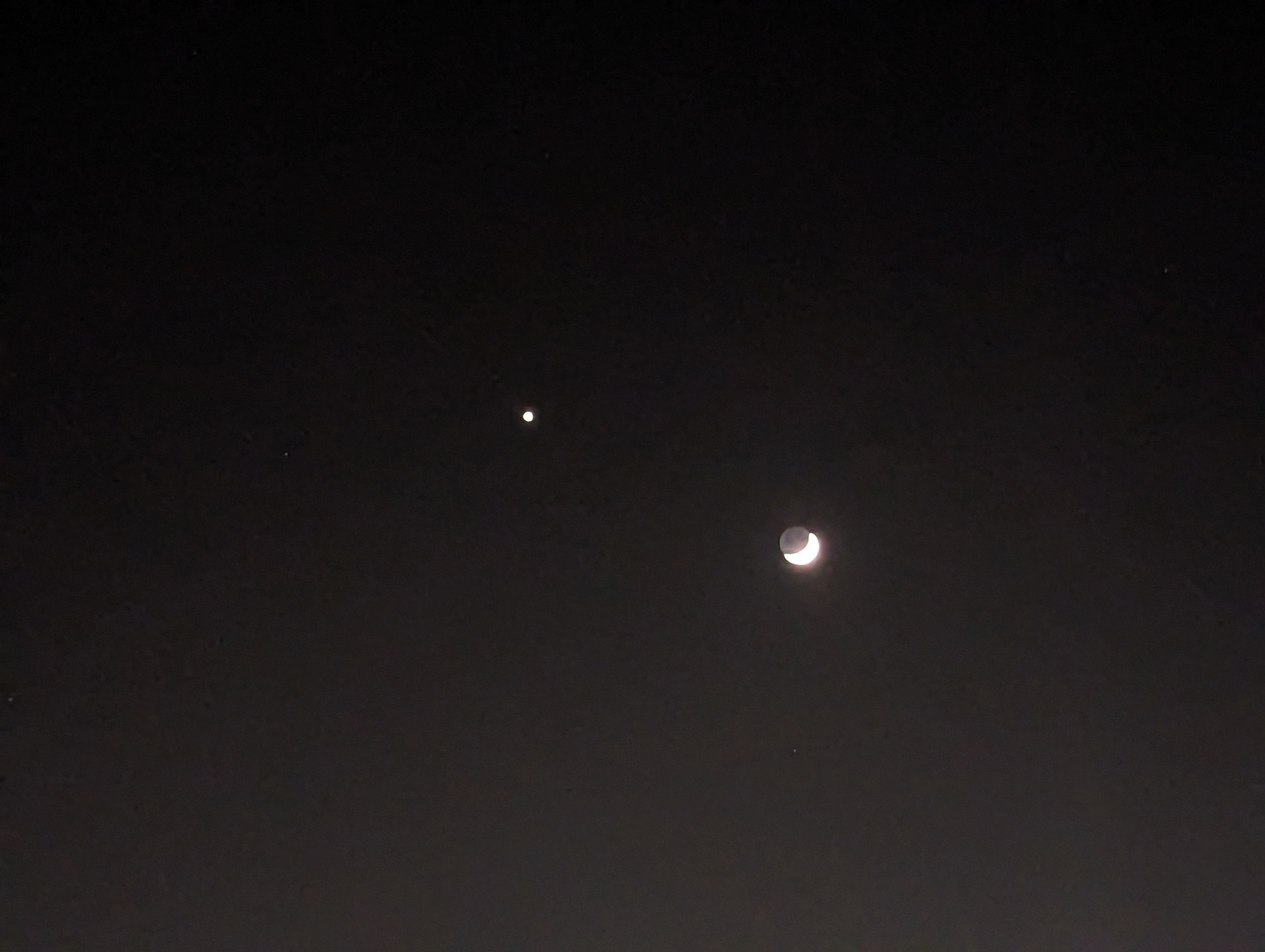 A cropped view of the planet Venus in evening star mode and the crescent moon a couple of days past newness, hanging out about three degrees apart in the sign of Cancer, as seen against clear dark sky Monday, May 22, 2023 in San Pablo, California.