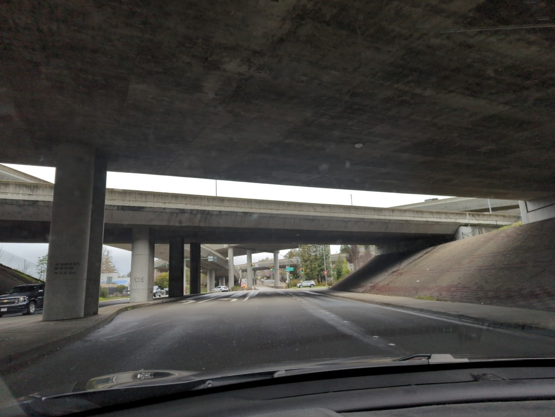 A look through my car windshield from underneath concrete overpasses for Interstate 680 toward westbound Highway 24 lanes Friday, March 10, 2023 from Boulevard Way in Walnut Creek, California.