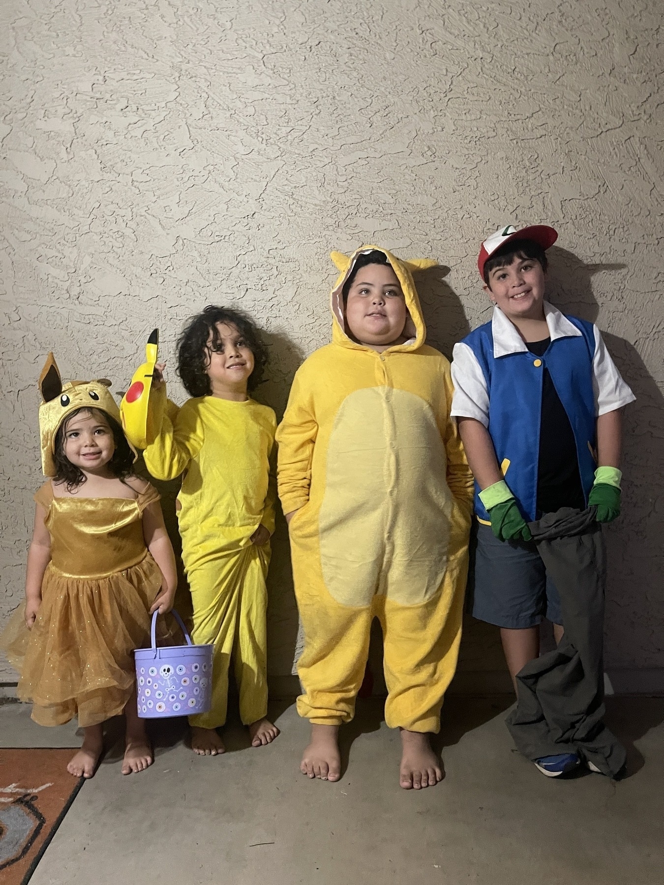 Four children in Pokemon costumes for Halloween