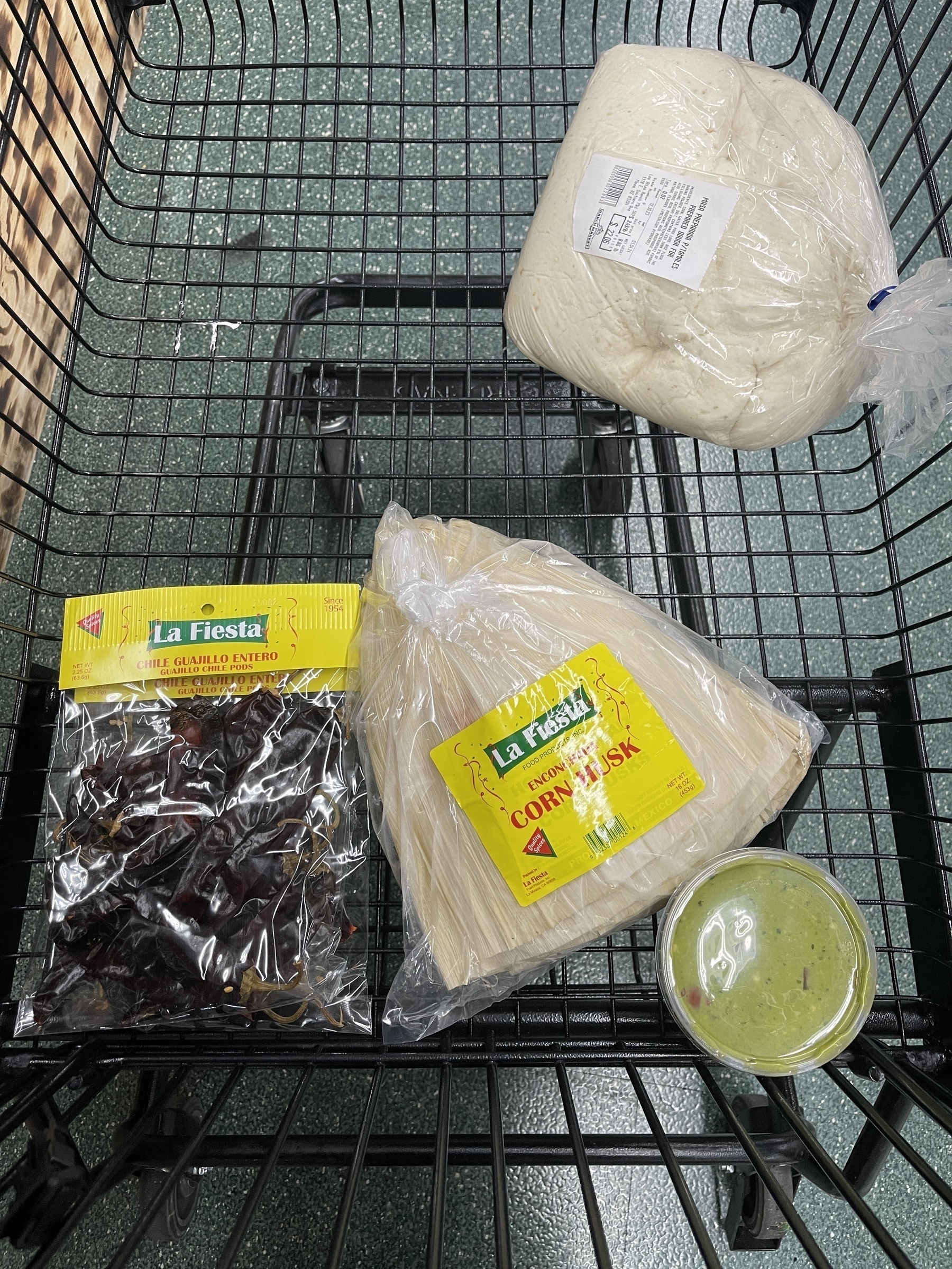 A photo of of a shopping cart full of tamales supplies, including 8 pounds of masa.