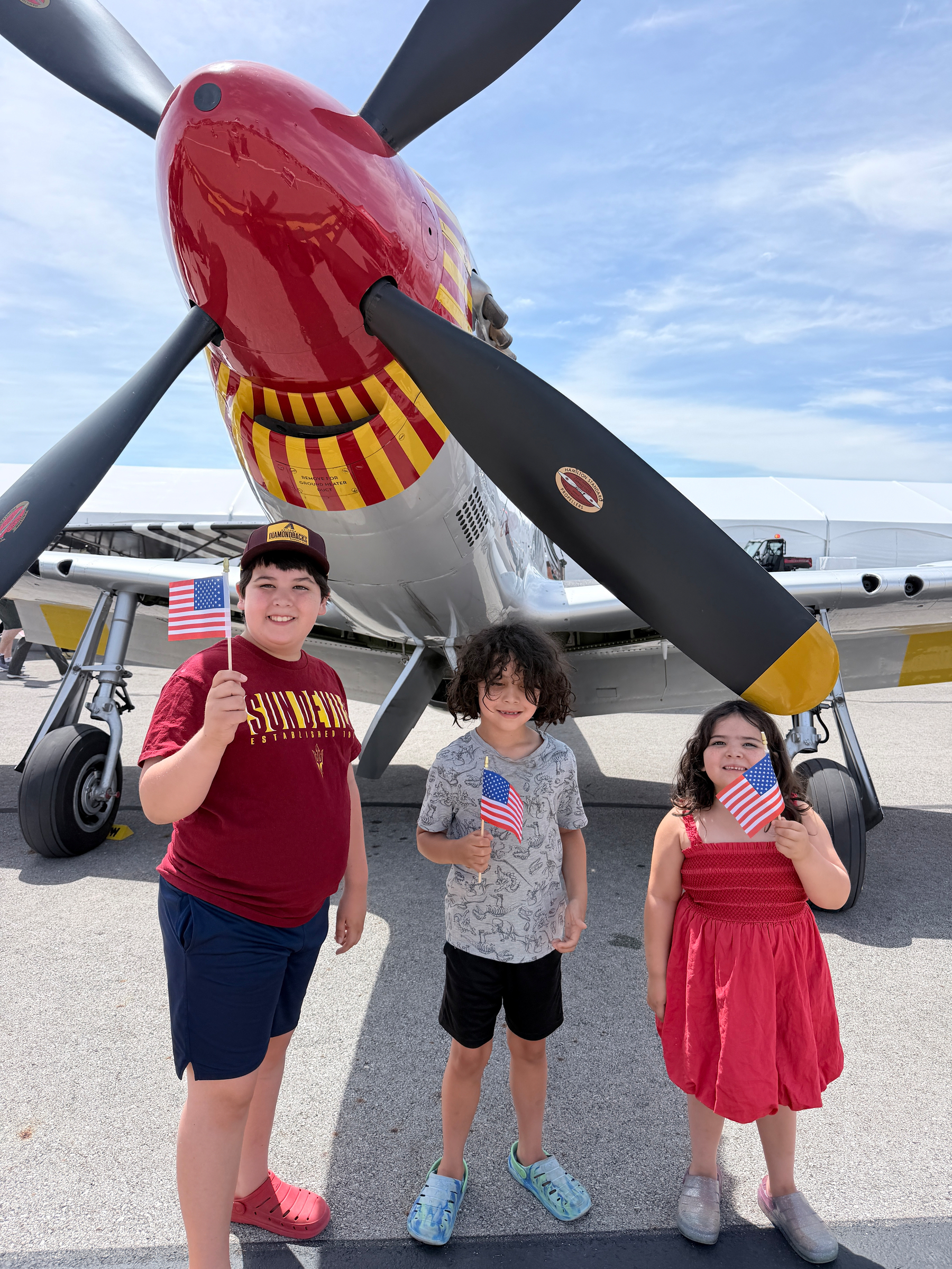 kids in front of P-51 Mustang display at an air show