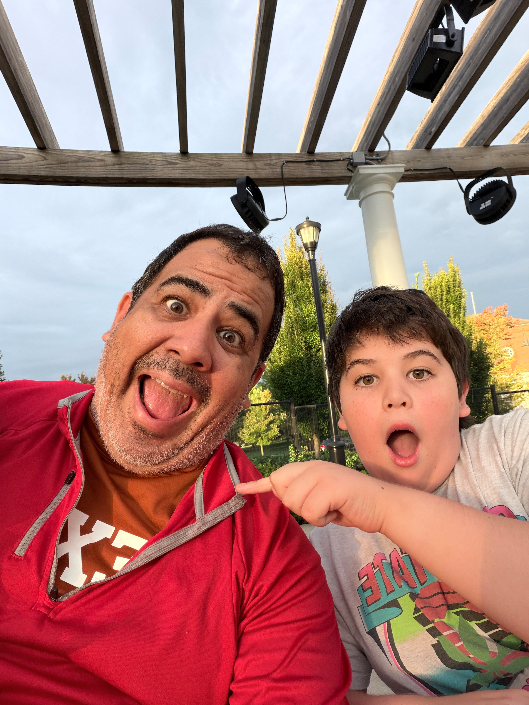 photo of man wearing Ohio State and Texas team colors while son pretends to be shocked