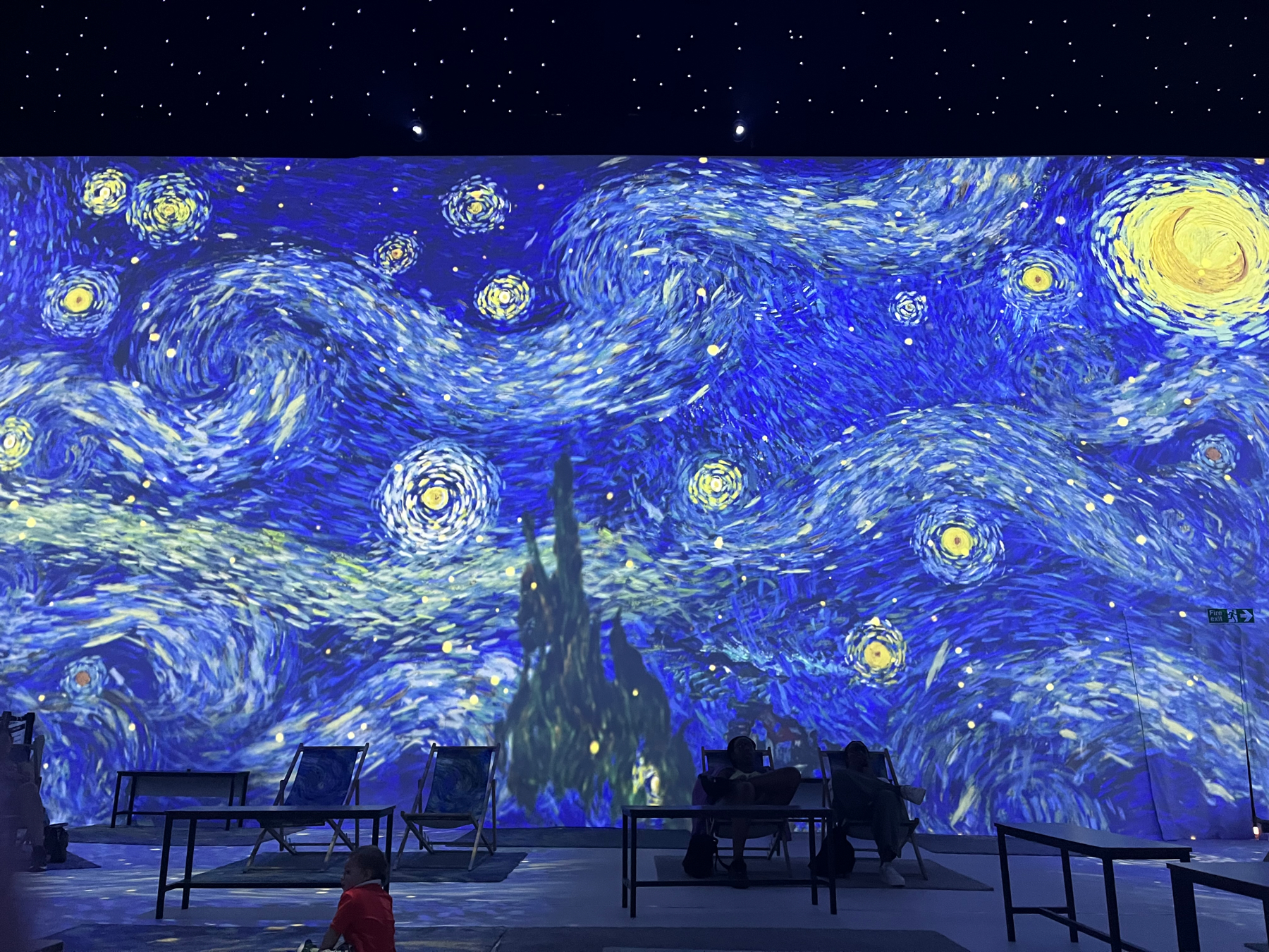 Van Gogh&rsquo;s Starry Night painting projected onto the walls of the exhibition