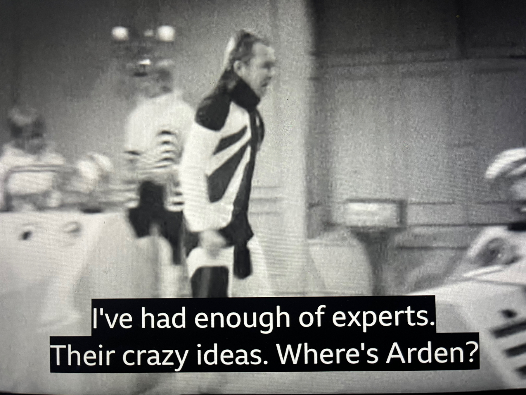 Doctor Who is speaking animatedly in a black and white scene with a caption that reads, I've had enough of experts. Their crazy ideas. Where's Arden?