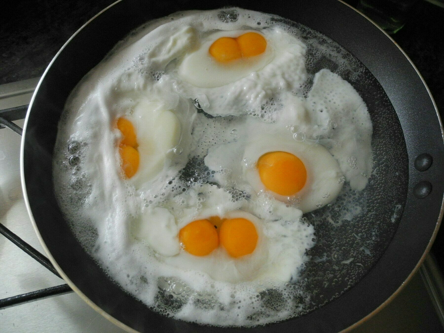 3 double-yolk eggs and 1 single-yolk eggs in a frying pan