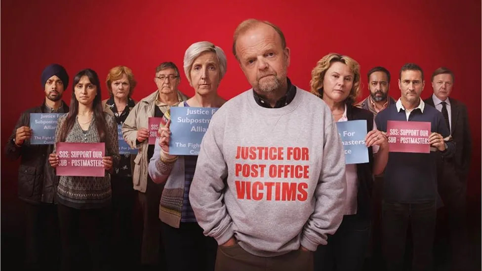 Photograph of the actors from Mr Bates vs The Post Office displaying Justice For Post Office victims related posters