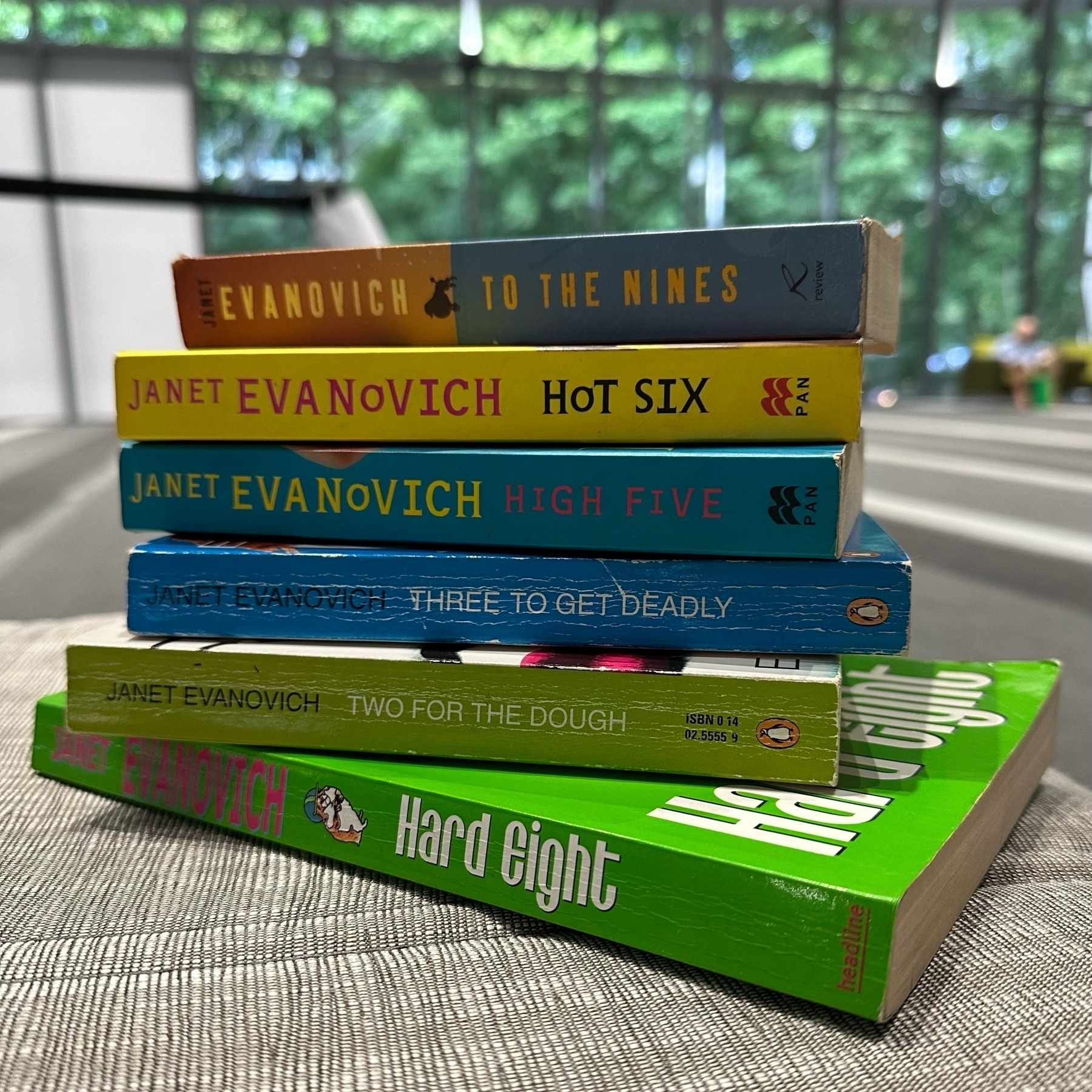Six books by Janet Evanovich stacked in a pile.